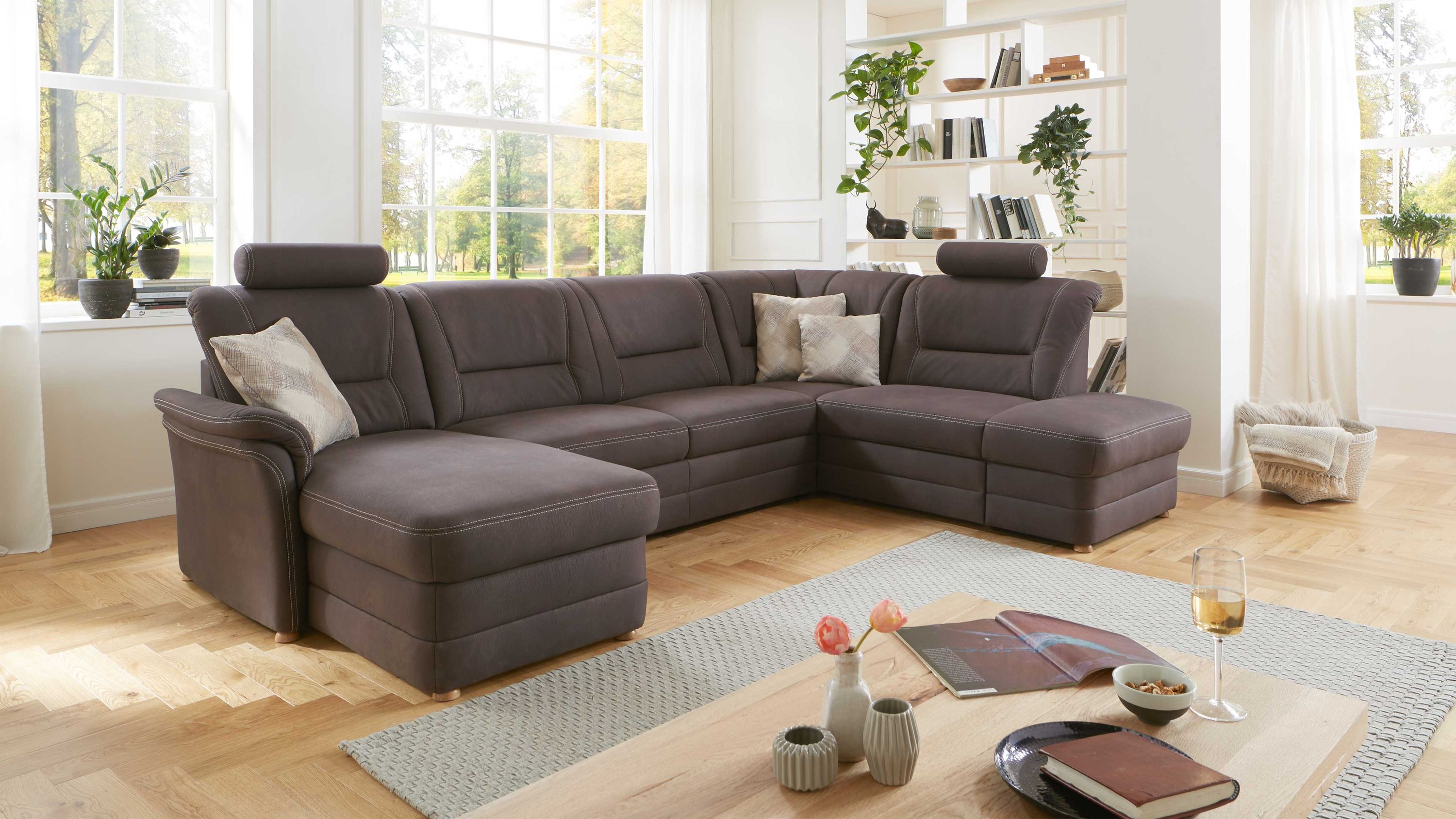 Wohnlandschaft in L-Form mit braunem Bezug Wohnlandschaft in L-Form mit braunem Bezug und verstellbaren Kopfstützen auf hellen Holzfüßen