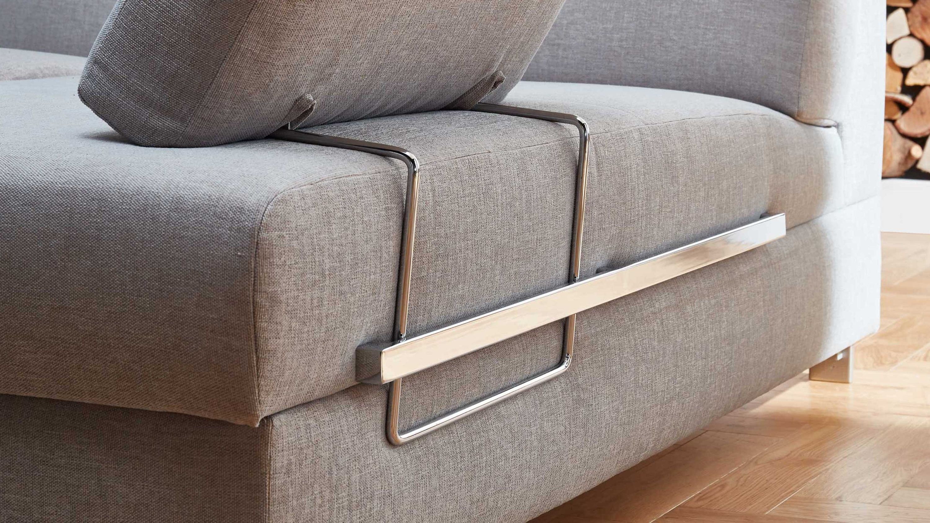 Nahaufnahme eines grauen Sofas mit verchromtem Metallrahmen zur Befestigung eines Rückenkissens