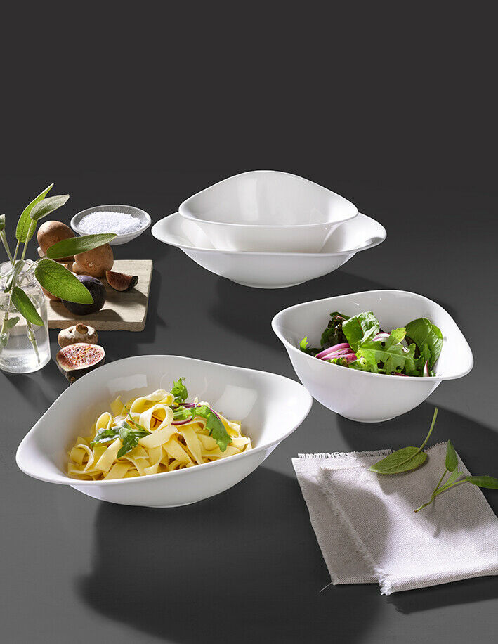 Pasta Set mit vier ovalen Porzellantellern  angerichtet mit Pasta und Salat  daneben eine Serviette