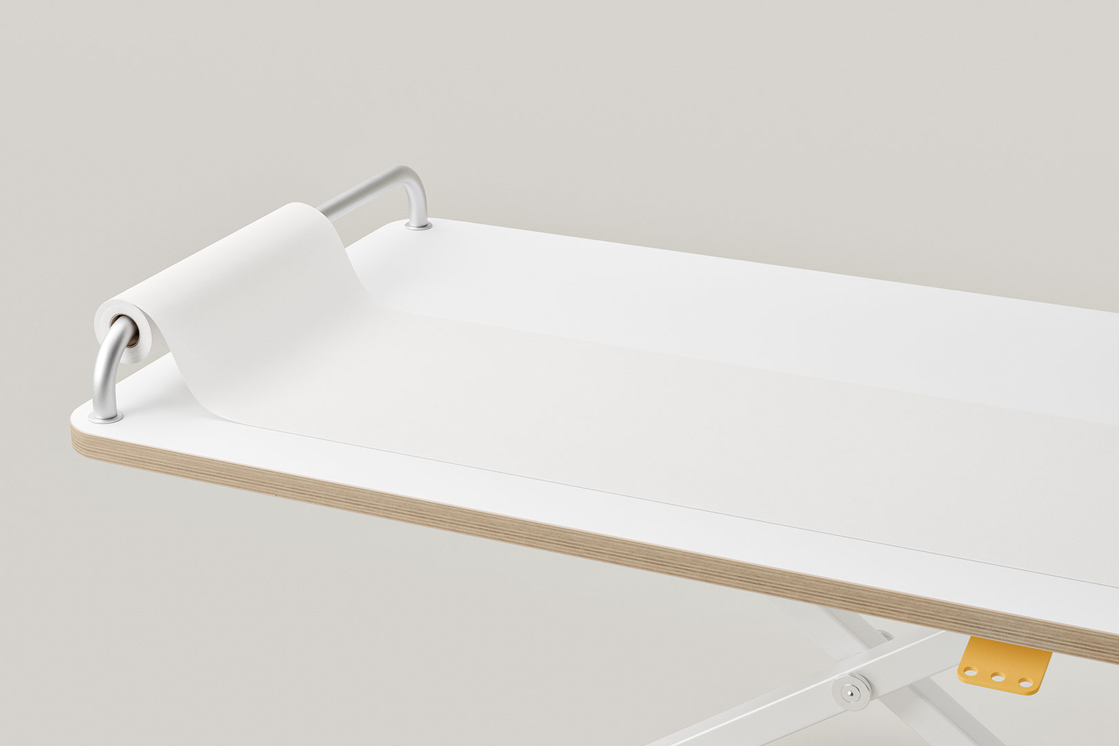 Weiße Papierrolle auf horizontaler Halterung am Ende einer flachen weißen Oberfläche.