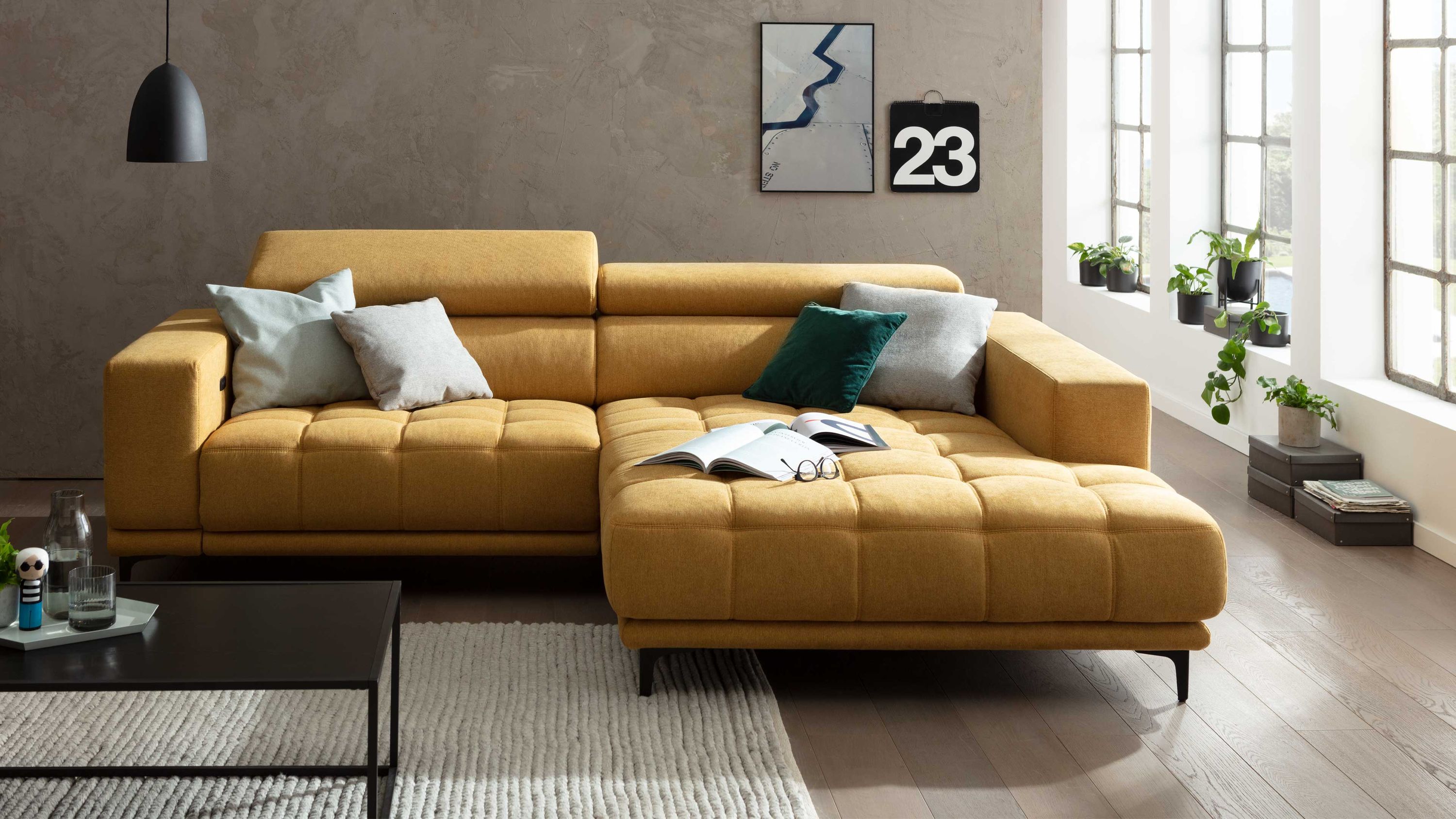 Ecksofa mit honiggelbem Stoffbezug und schwarzen Metallfüßen mit Kissen und niedriger Rückenlehne