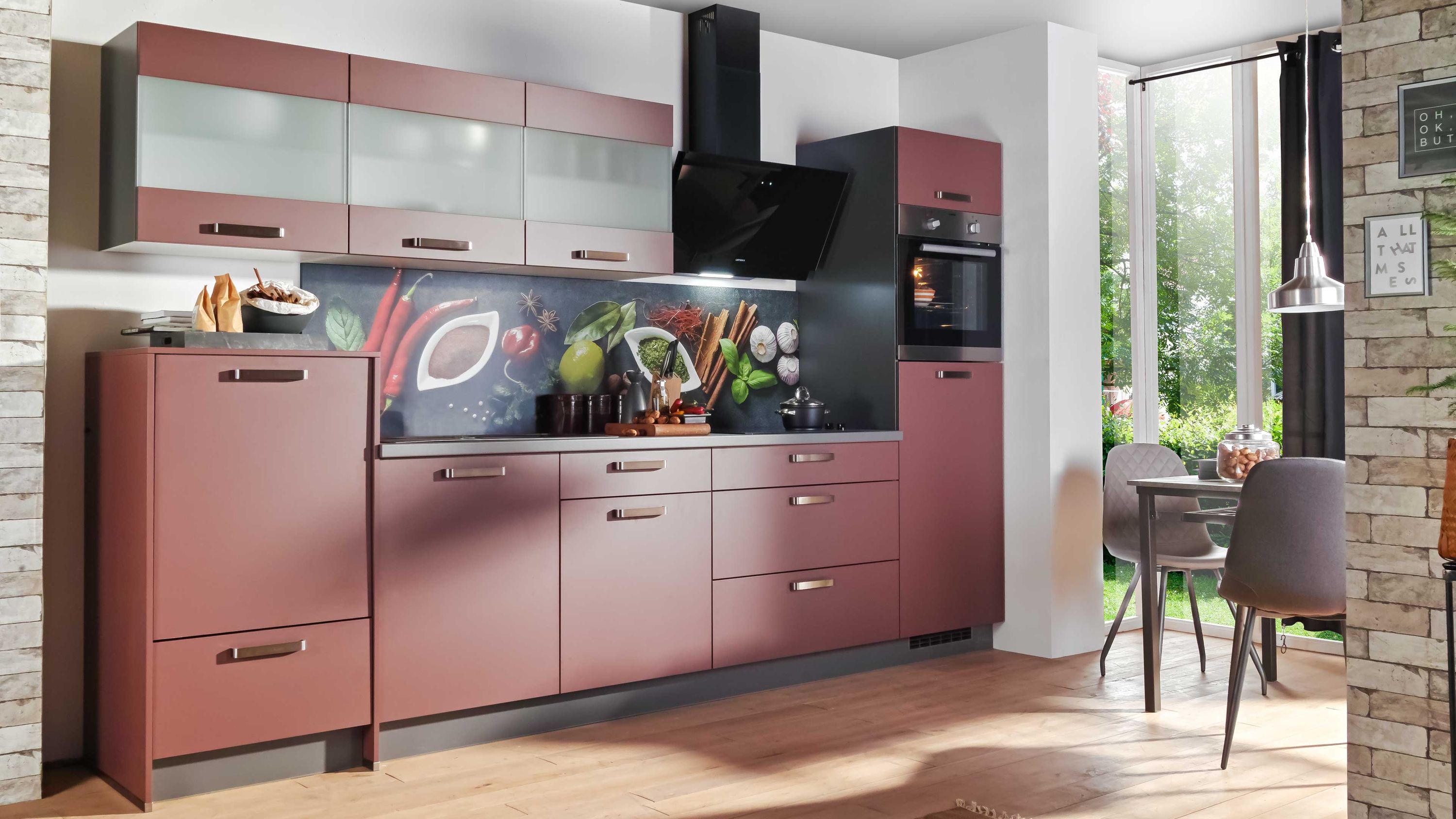 Moderne Küche in Rot mit Glasoberschränken schwarzer Arbeitsplatte und dekorativer Rückwand.