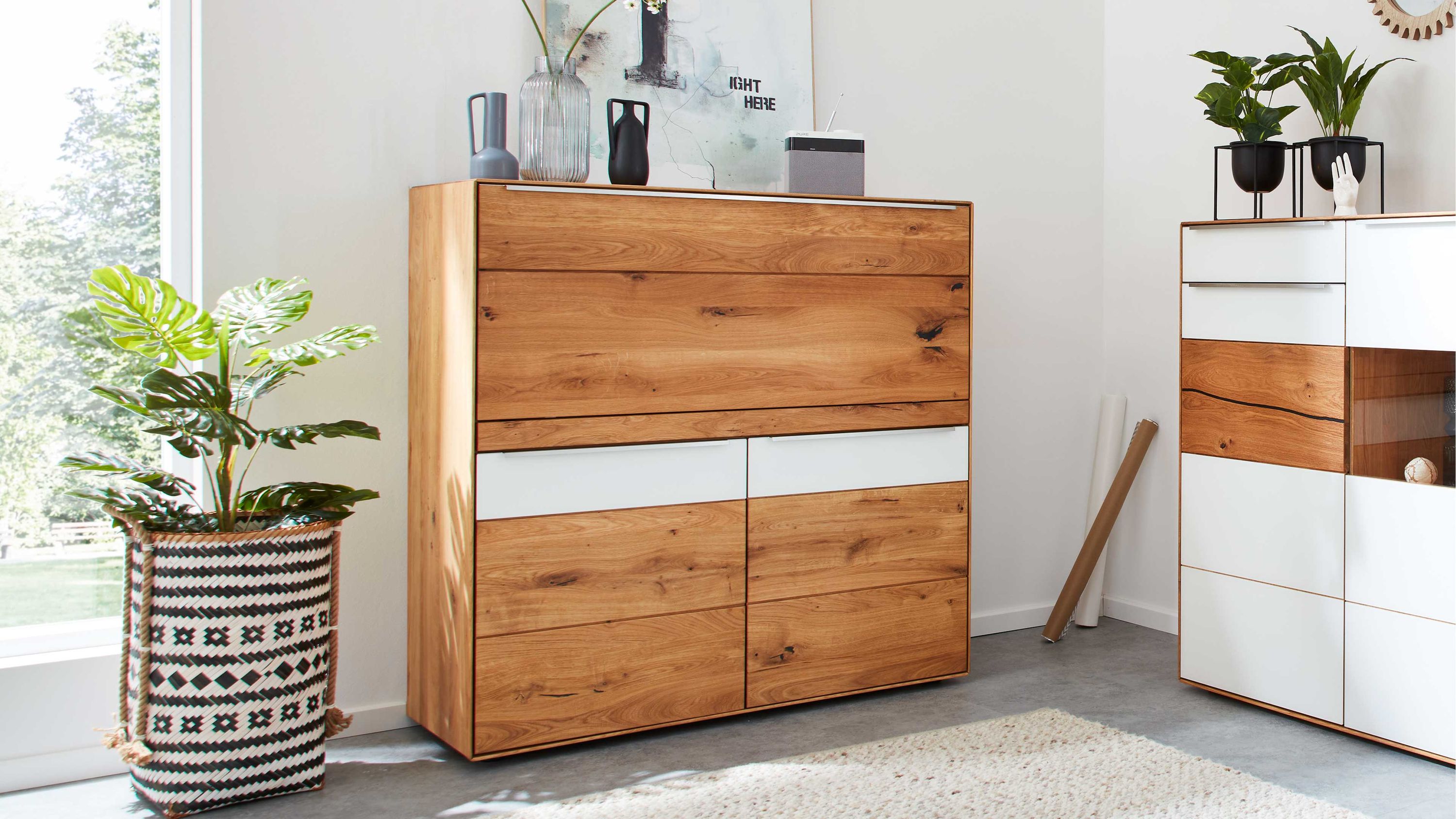 Highboard mit zwei Türen und Schreibplatte in Holzoptik und weißen Fronten in modernem Wohnzimmer