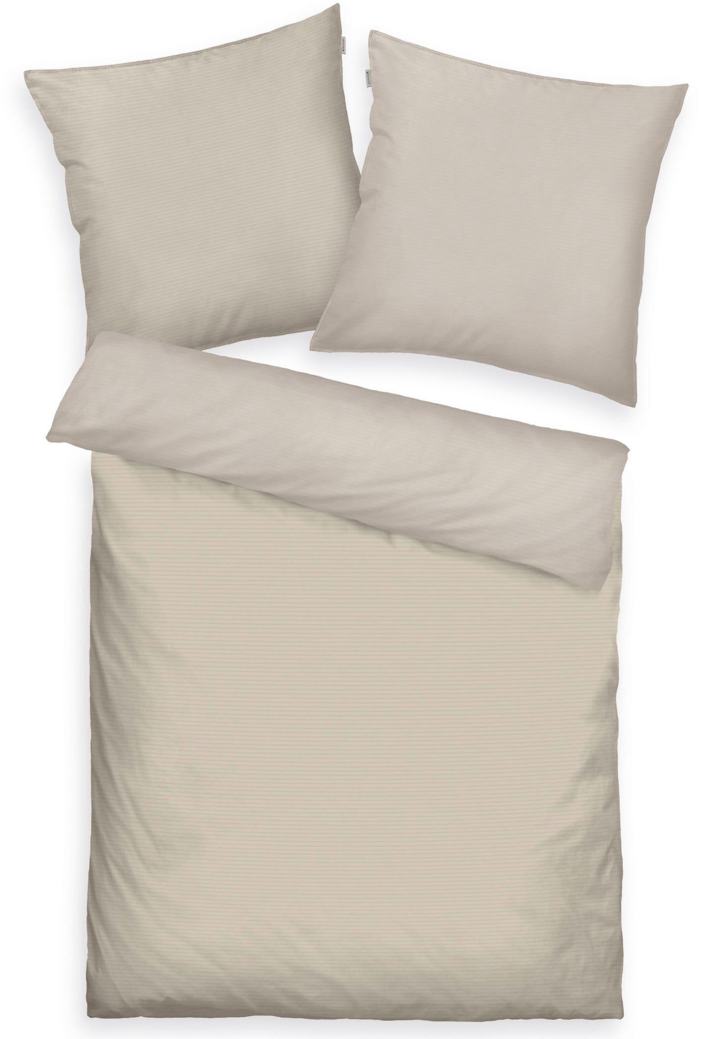 Draufsicht auf Bett mit zwei Kissen und Decke beige auf einer Seite und hellbraun auf der anderen symmetrisch angeordnet
