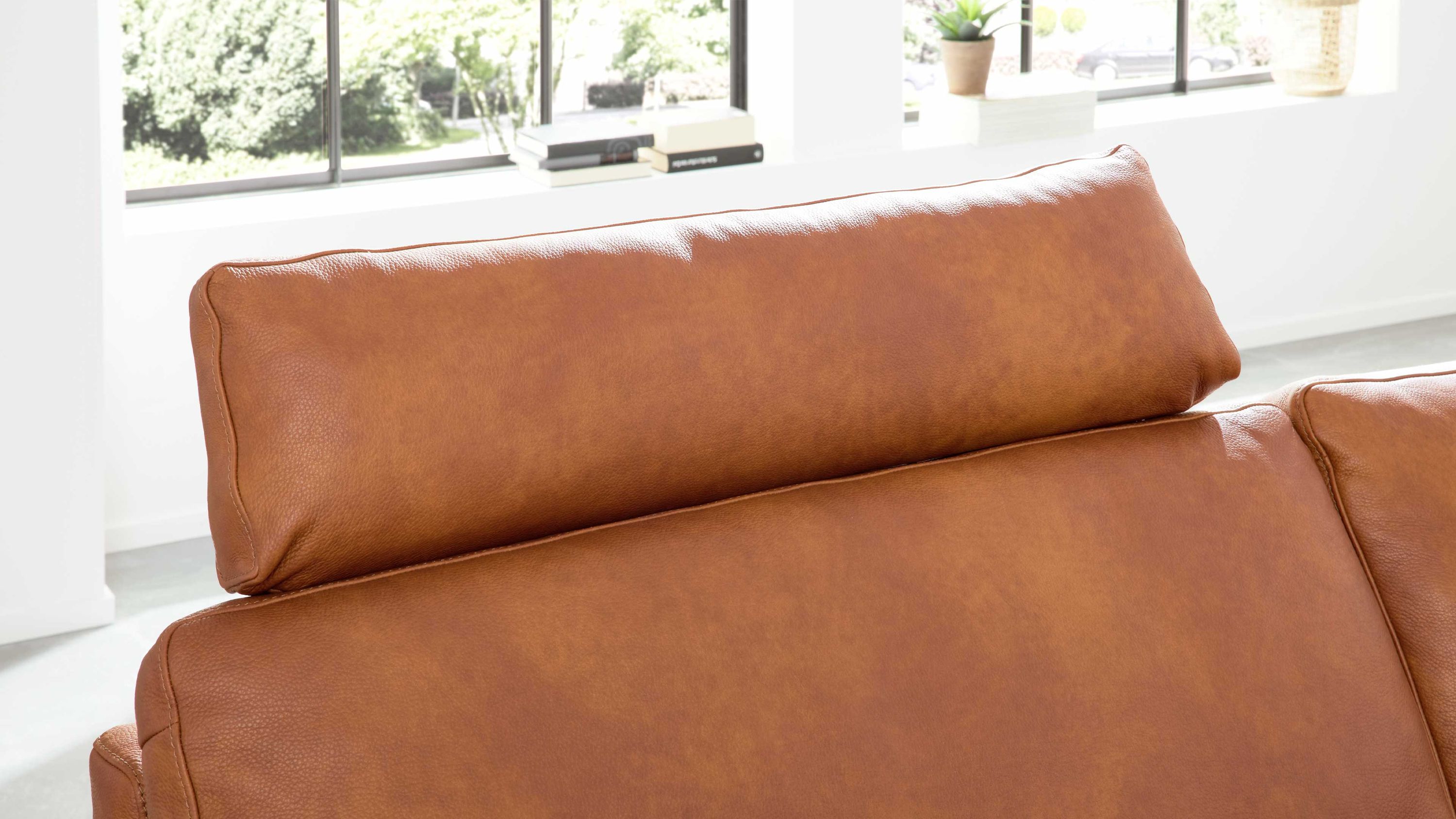 Kopfstütze in rechteckiger Form aus cognacfarbenem Leder auf einem Sofa