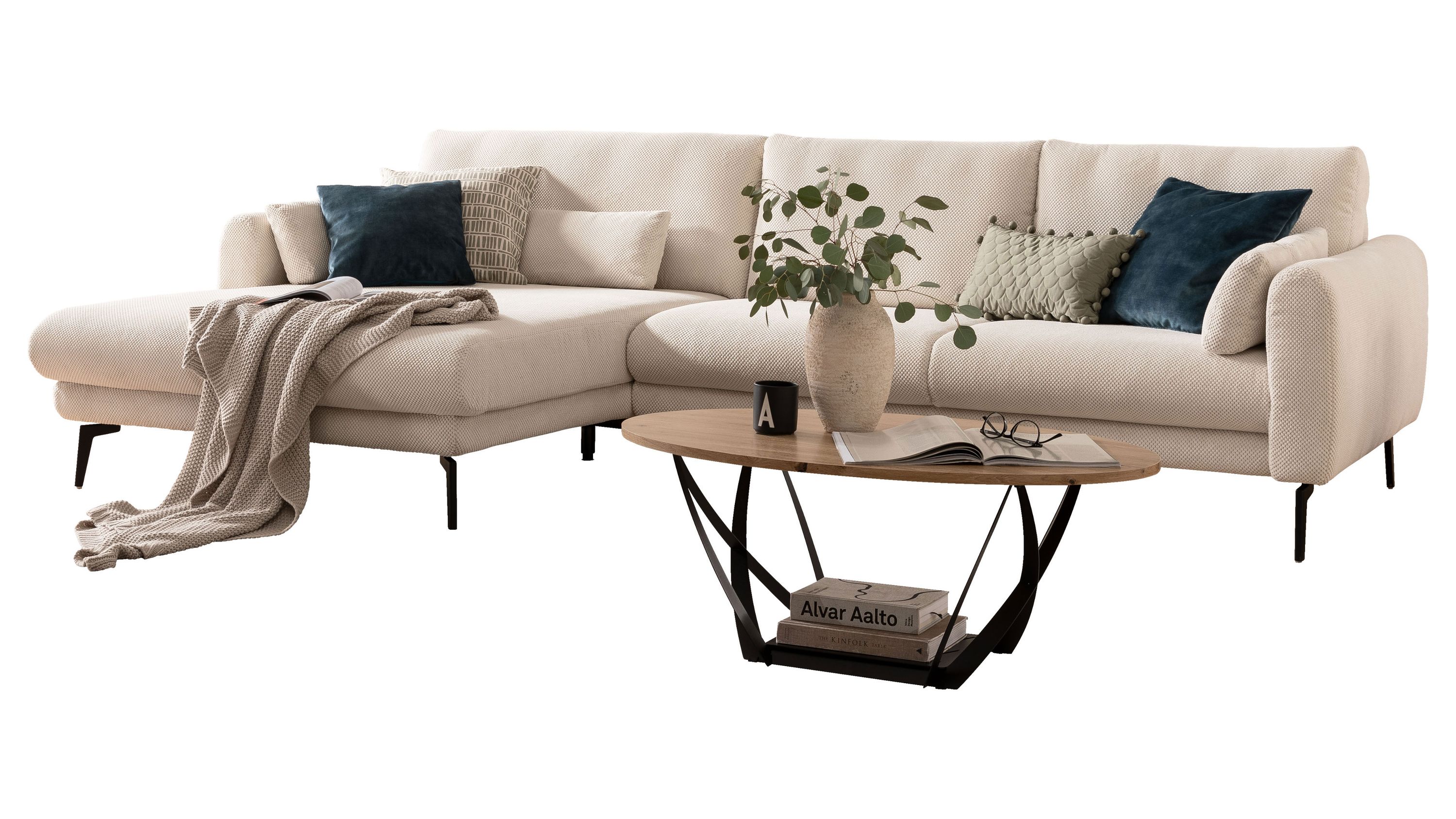Ecksofa mit naturfarbenem Stoffbezug und schwarzen Metallfüßen mit mehreren Kissen und Decke