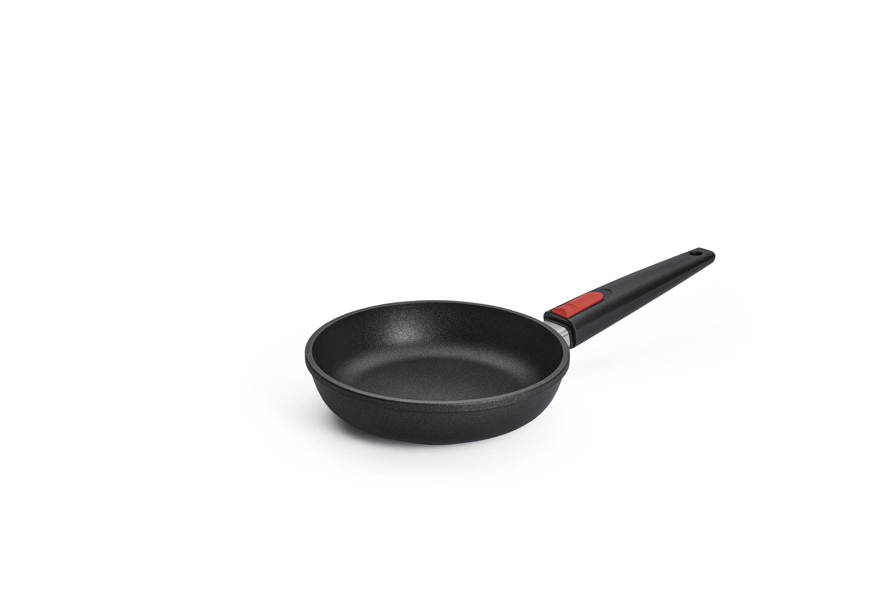 WOLL-Bratpfanne mit abnehmbarem Griff. Schwarze WOLL-Bratpfanne mit abnehmbarem Griff und rotem Druckknopf, leicht schräg von oben aufgenommen, ohne Deckel.