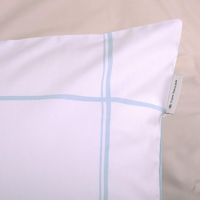 Nahaufnahme eines Kissenbezugs mit weißem Grund und blauen Streifen Rückseite blau mit weißen Streifen kariert