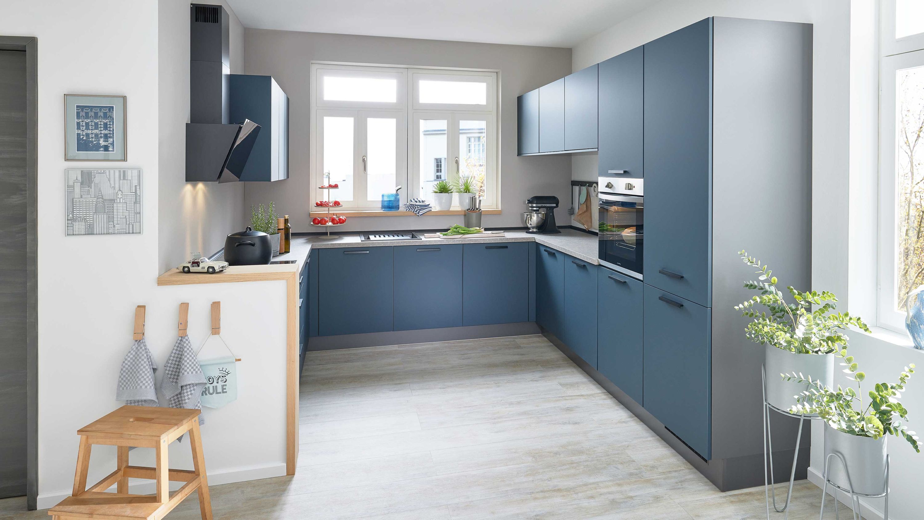 mit Moderne Küche in Blau mit U-Form hellen Arbeitsflächen und großem Fenster.