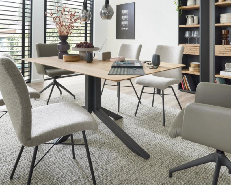 Moderne Essgruppe im Industrial-Stil mit Holzdetails, gemütlichen Stühlen und luftiger Regalwand. Essgruppe mit Holztisch, gepolsterten Stühlen und Regalwand in modernem Industrial-Stil mit offenen Lamellenfenstern