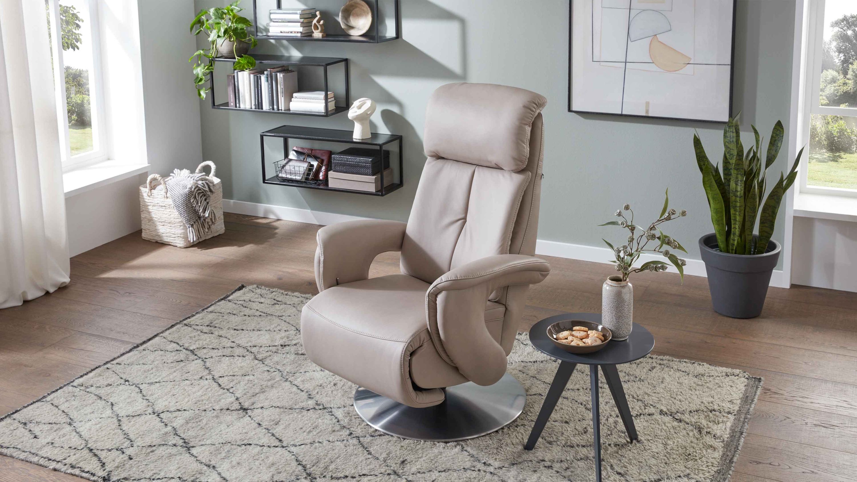 Beiger Relaxsessel mit hoher Rückenlehne und Armlehnen auf rundem Tellerfuß in modernem Wohnzimmer