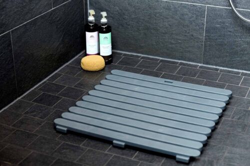 Duschboden mit Matte und Pflegeprodukten Dunkler Duschboden mit grauer Matte, zwei Duschflaschen und gelbem Schwamm in der Ecke, von oben fotografiert