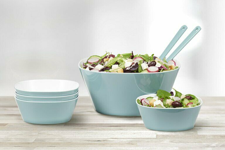 Blaues Schüssel-Set auf Holzfläche, größte Schüssel mit Salat und Besteck, kleinere Schüsseln daneben