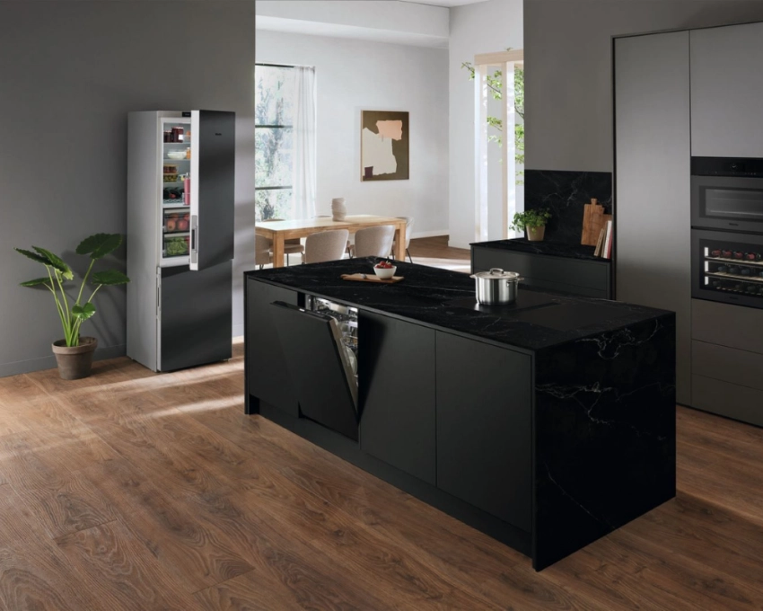 Miele Designküche in Schwarz mit Kochinsel Offene Küche mit schwarzer Miele-Kochinsel, integriertem Kochfeld und modernem Holzfußboden