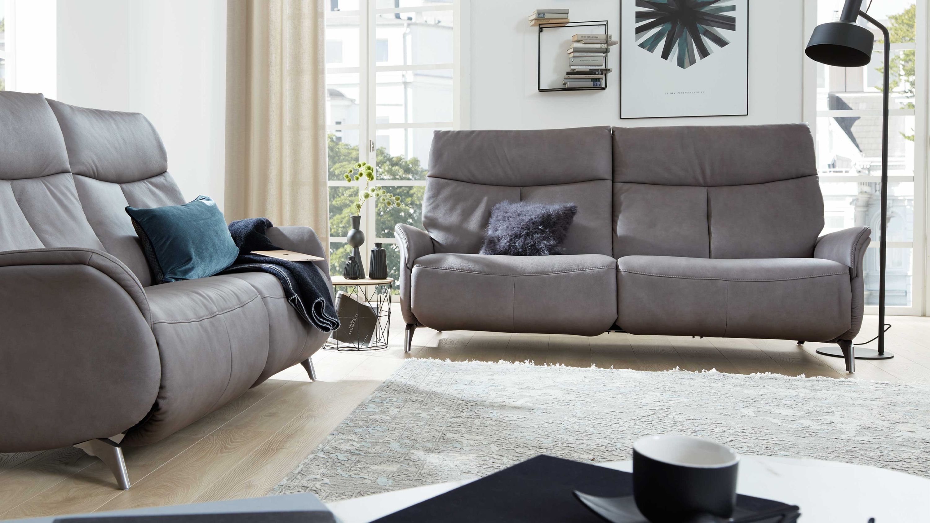 Zweisitziges Sofa in grauer Farbe mit gepolsterten Armlehnen und Metallfüßen in modernem Wohnzimmer