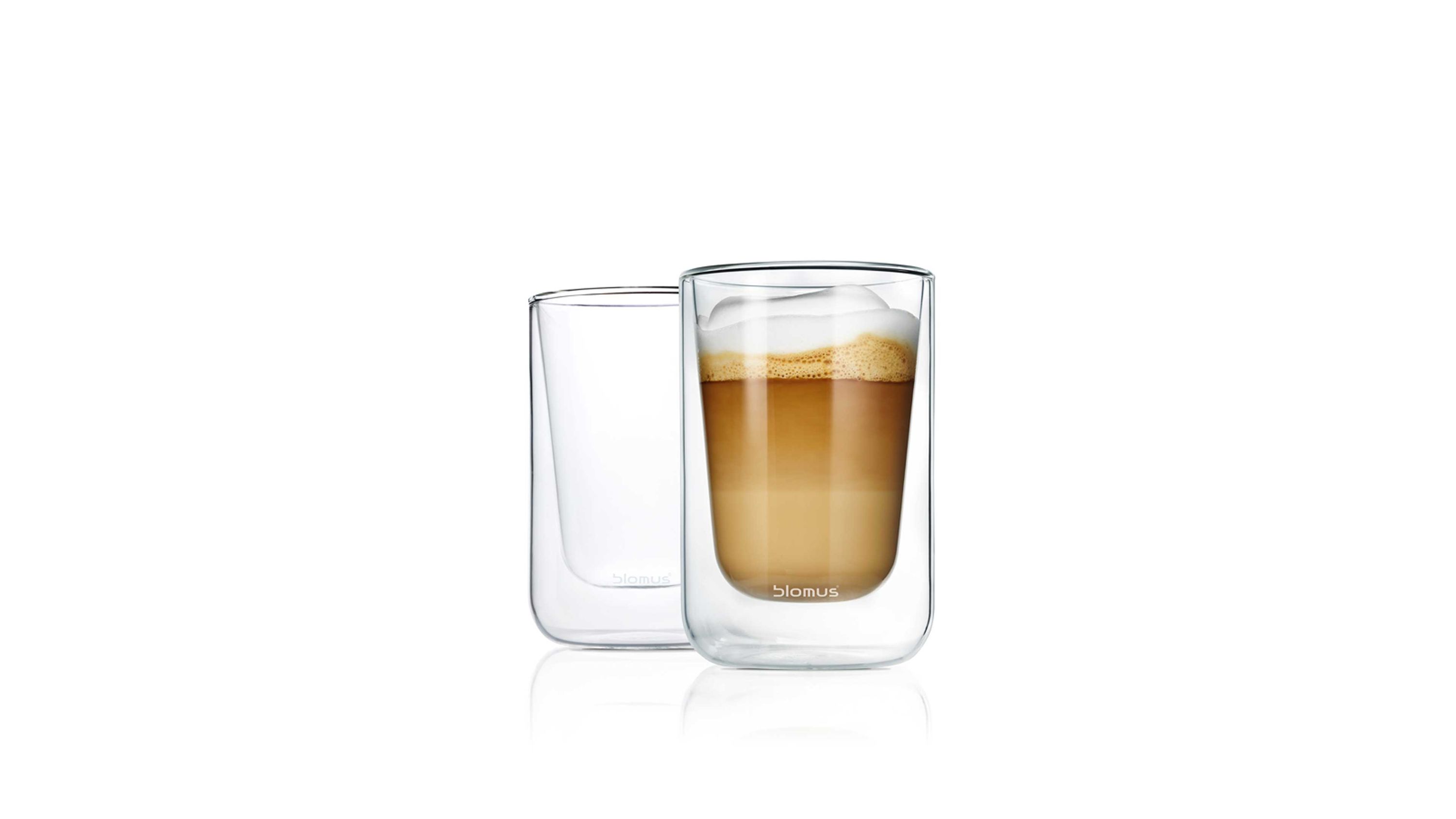 Zwei transparente Doppelwandgläser mit zylindrischer Form eines gefüllt mit Kaffee und Schaum