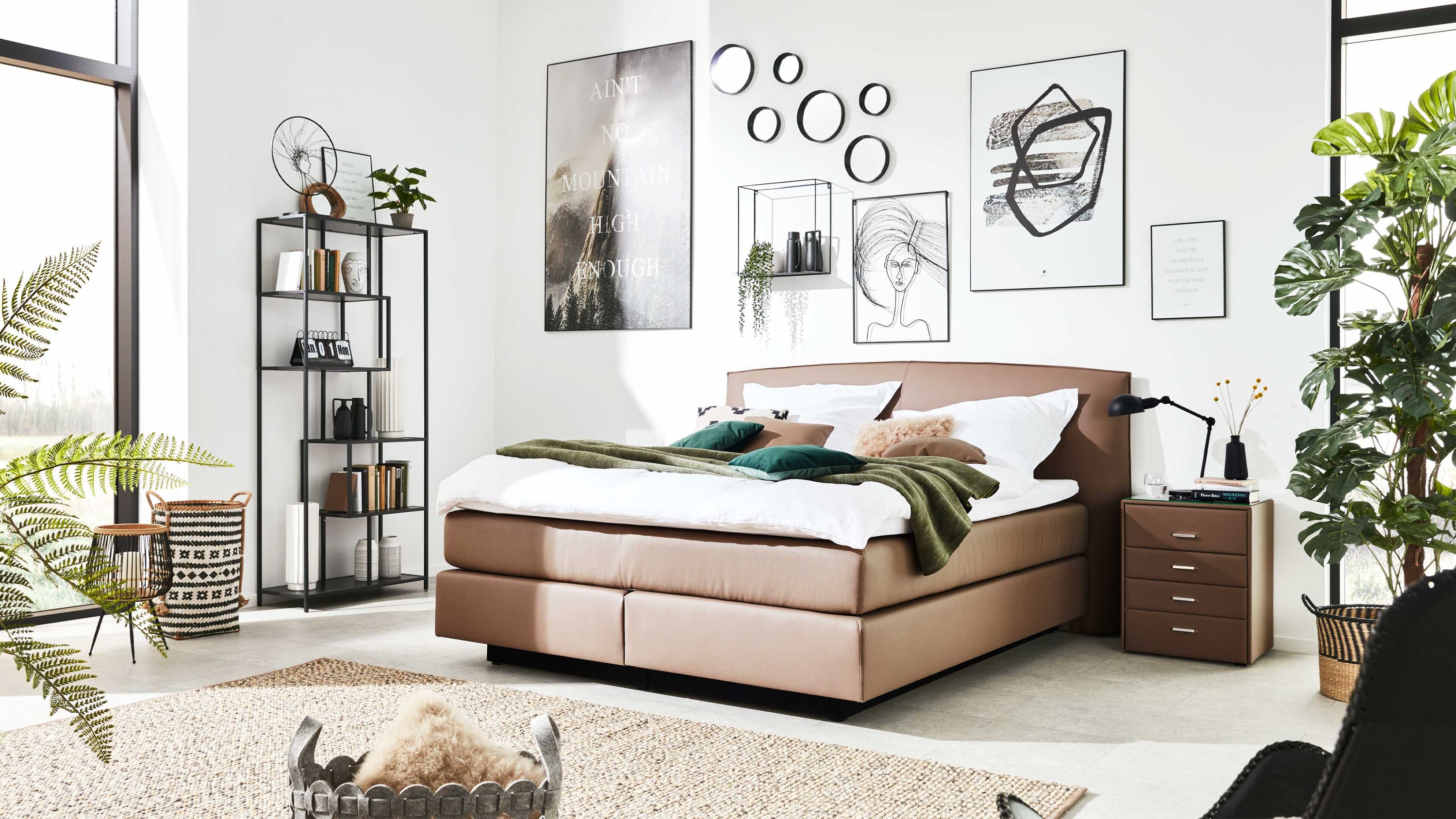 Boxspringbett in schlammfarbenem Kunstleder mit Kopfteil in modernem Schlafzimmer mit Nachttisch und Regal