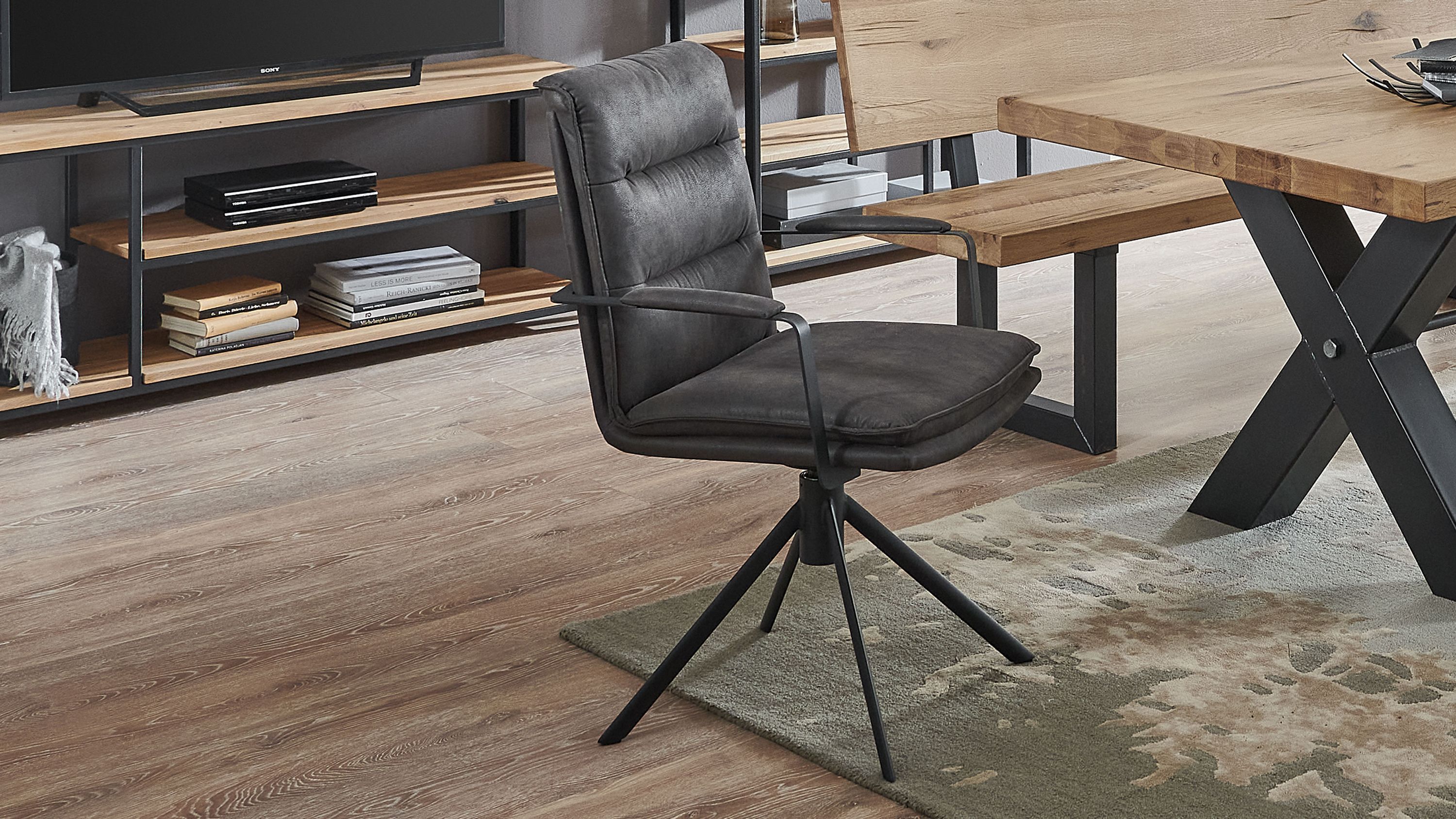 Armlehnstuhl mit anthrazitfarbener Polsterung und schwarzem Metallgestell Armlehnstuhl mit gepolsterter Rückenlehne und Sitzfläche in anthrazit auf schwarzem Metallgestell mit vier Beinen