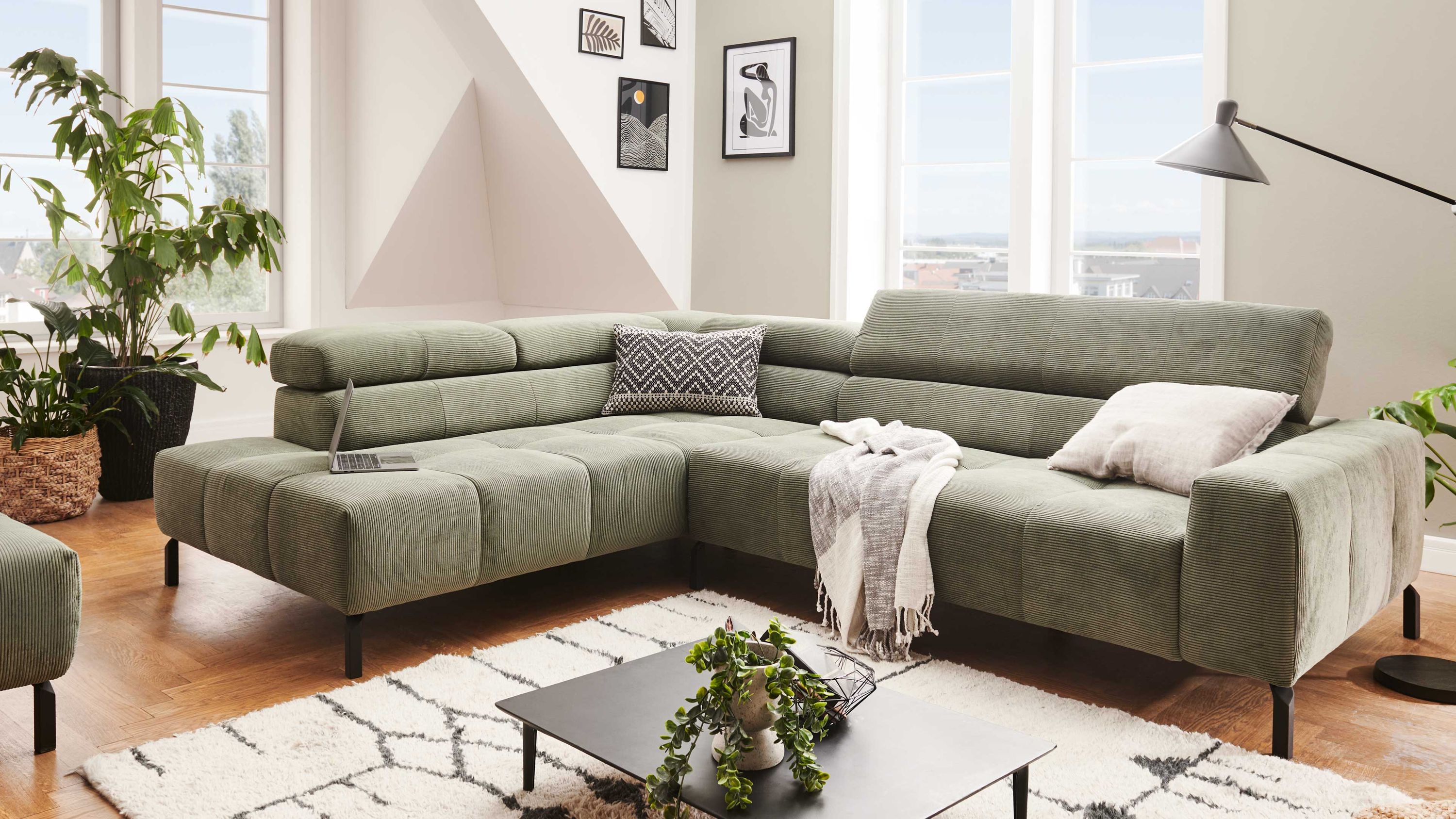 Ecksofa mit olivgrünem Feincordbezug Ecksofa mit olivgrünem Feincordbezug und verstellbaren Rückenlehnen in modernem Wohnzimmer