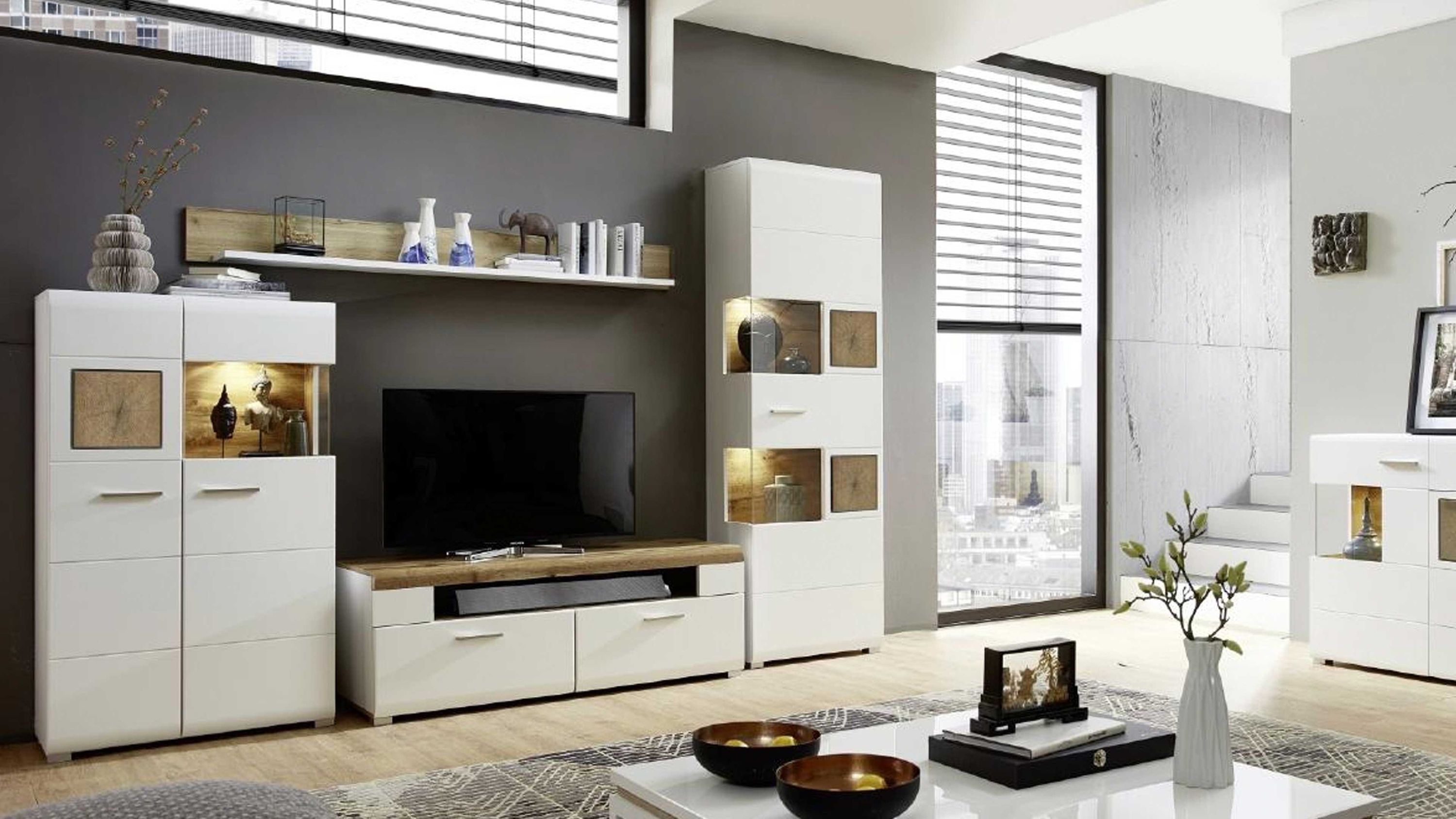 Vierteilige Wohnwand mit weißen Fronten und Holzflächen Vierteilige Wohnwand mit weißen Fronten und Holzflächen integrierte Beleuchtung in Vitrinen modernes Wohnzimmer