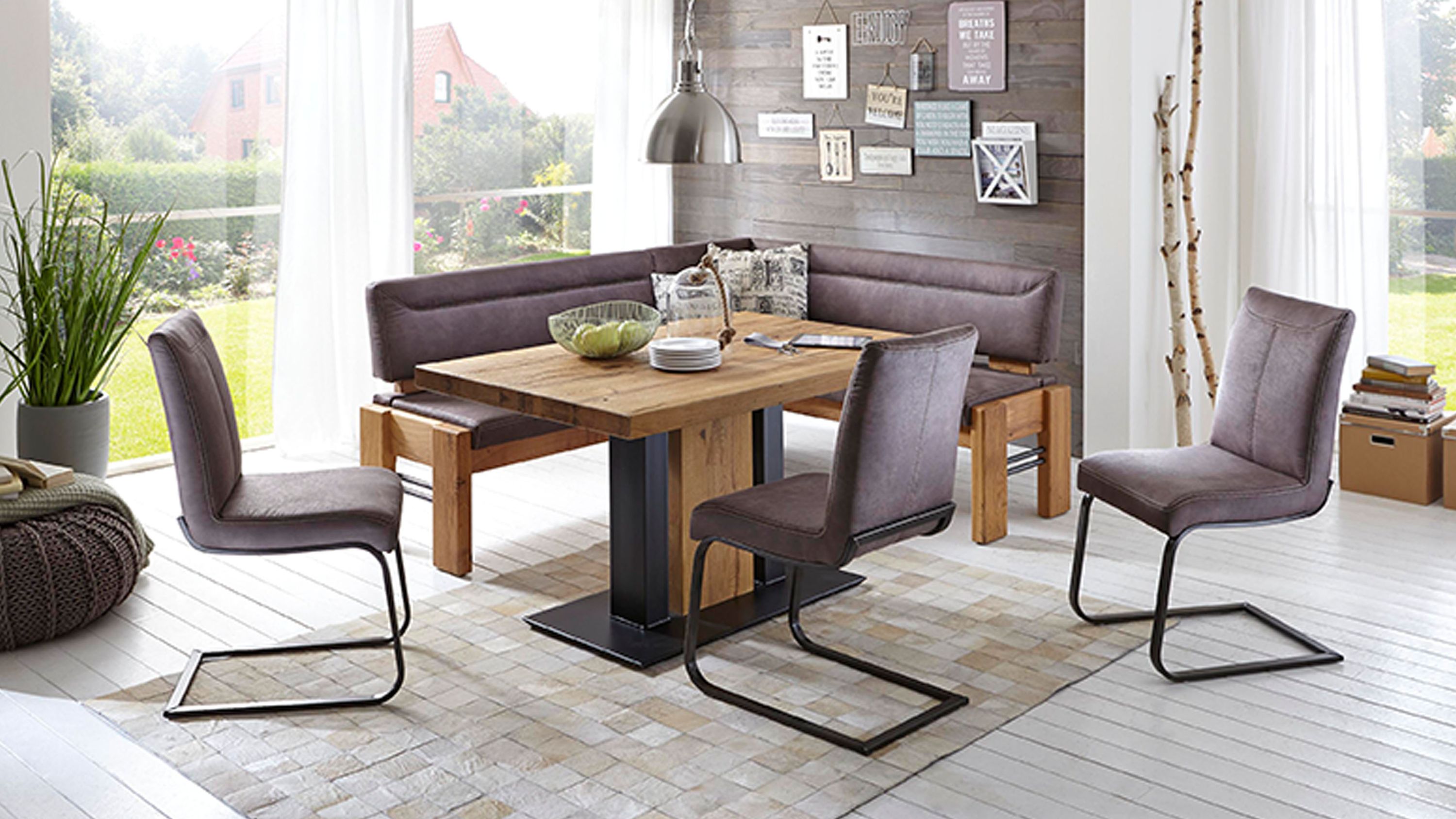 Esstisch mit Eckbank und Stühlen in modernem Esszimmer Quadratischer Esstisch mit Holzplatte und schwarzem Metallfuß umgeben von Eckbank und vier gepolsterten Stühlen in Grau
