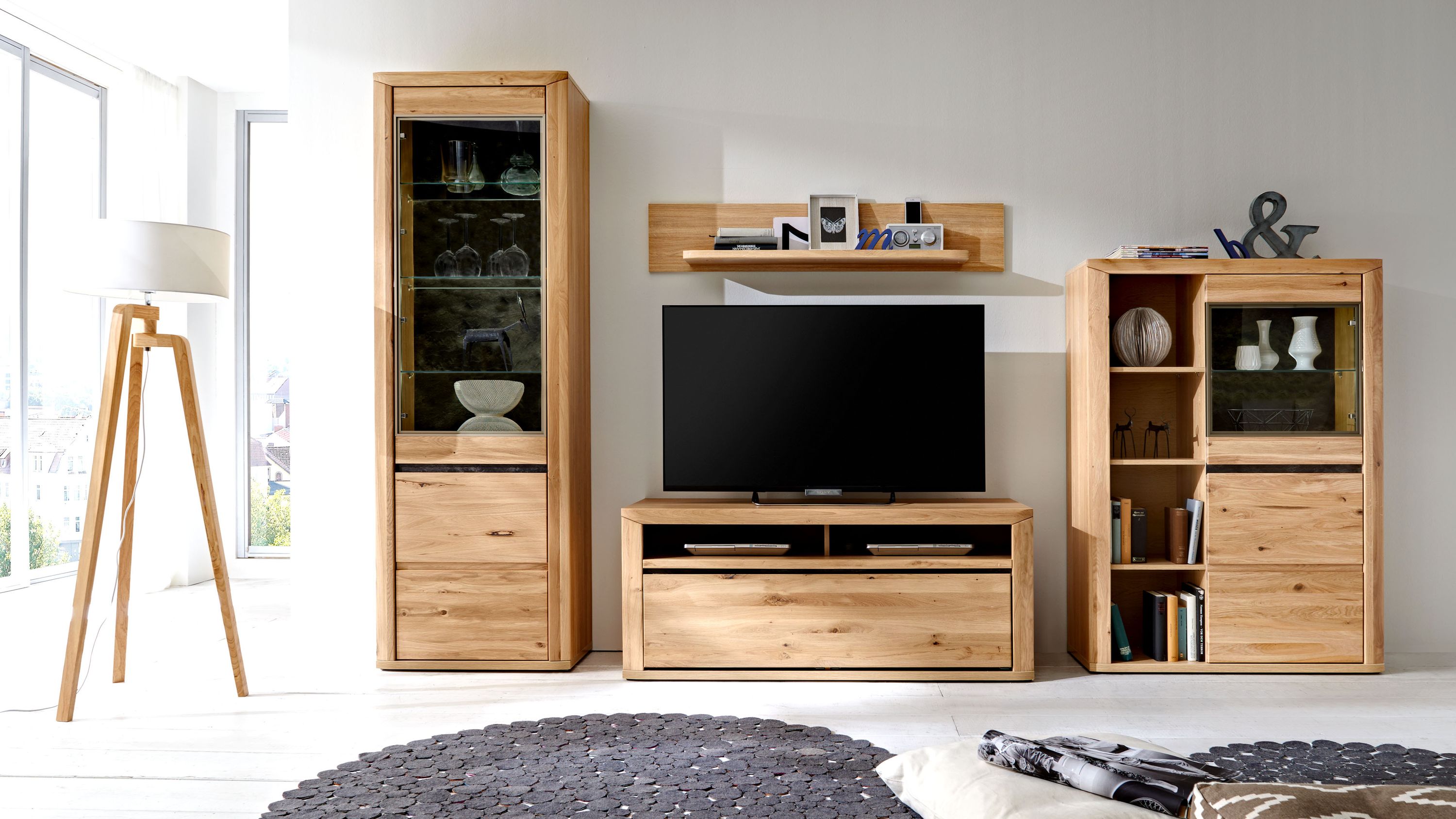 Wohnwand aus hellem Holz mit Vitrinenschrank TV-Board und Regal mit offenen Fächern und Glastüren