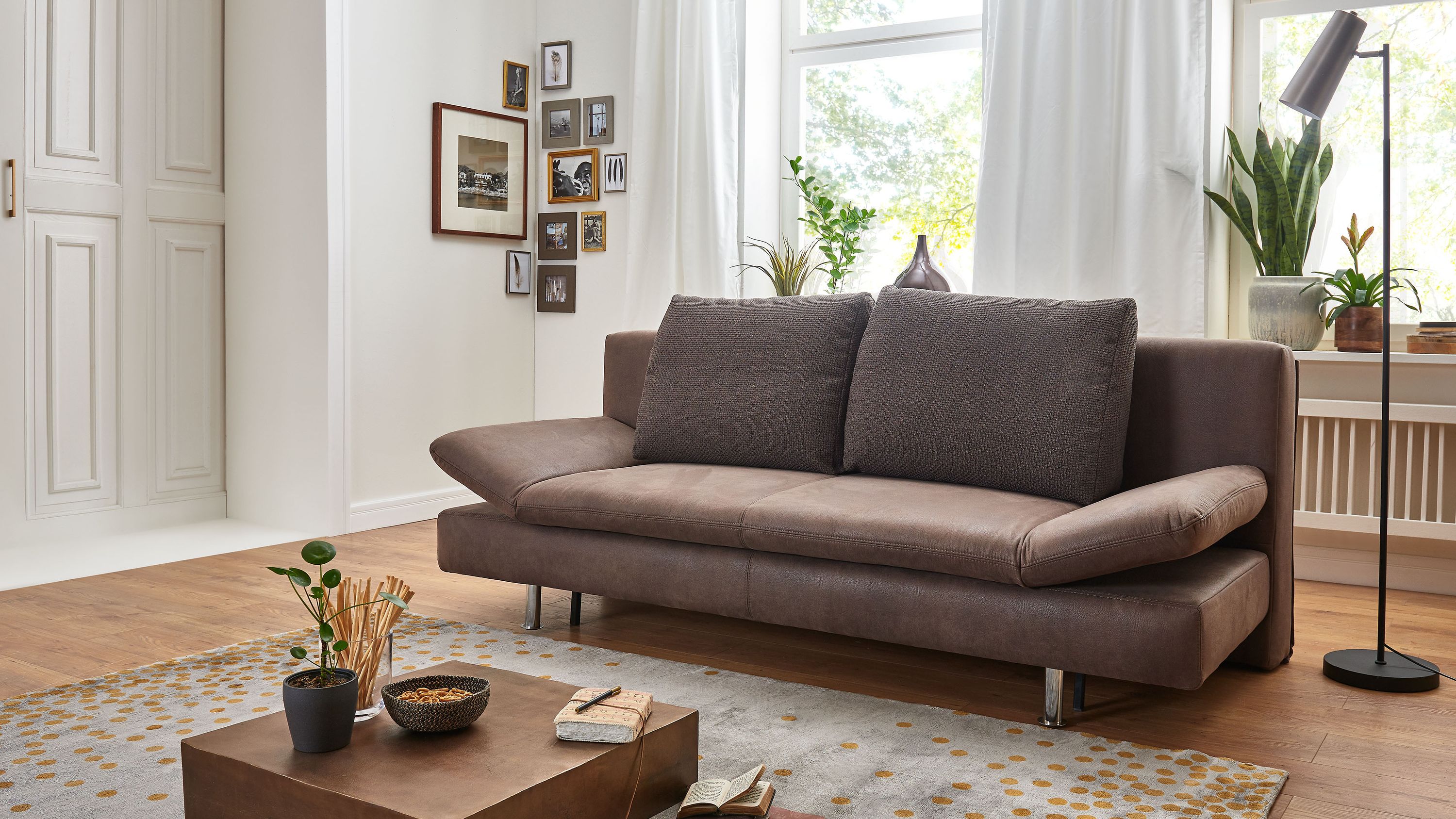 Braunes Schlafsofa mit Chromfüßen Braunes Schlafsofa mit zwei Rückenkissen und verstellbaren Armlehnen auf Chromfüßen
