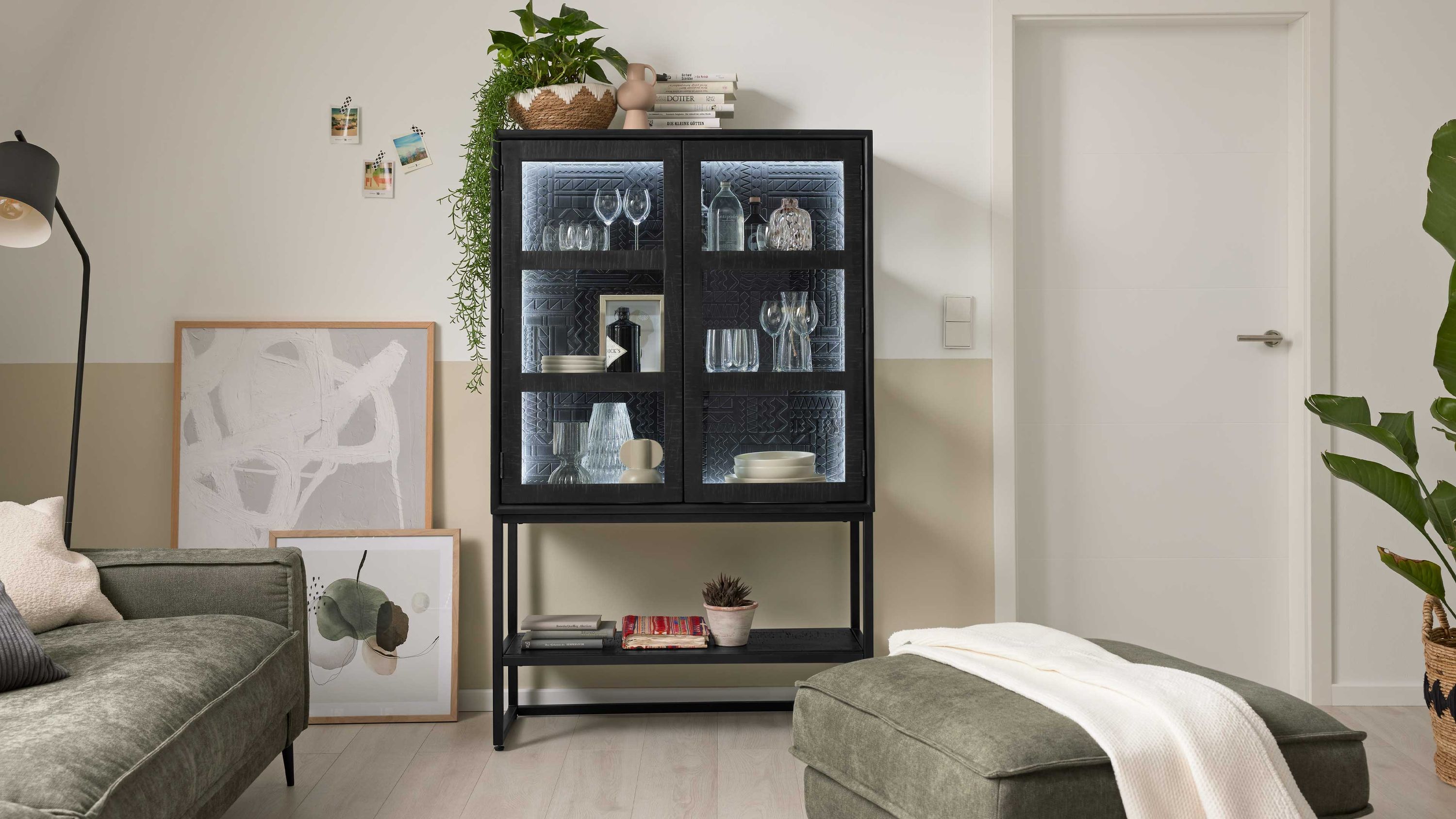 Vitrine mit zwei Glastüren und Ablagefach in Schwarz Schwarze Vitrine mit zwei Glastüren Regalfach unten dekoriert mit Gläsern und Büchern