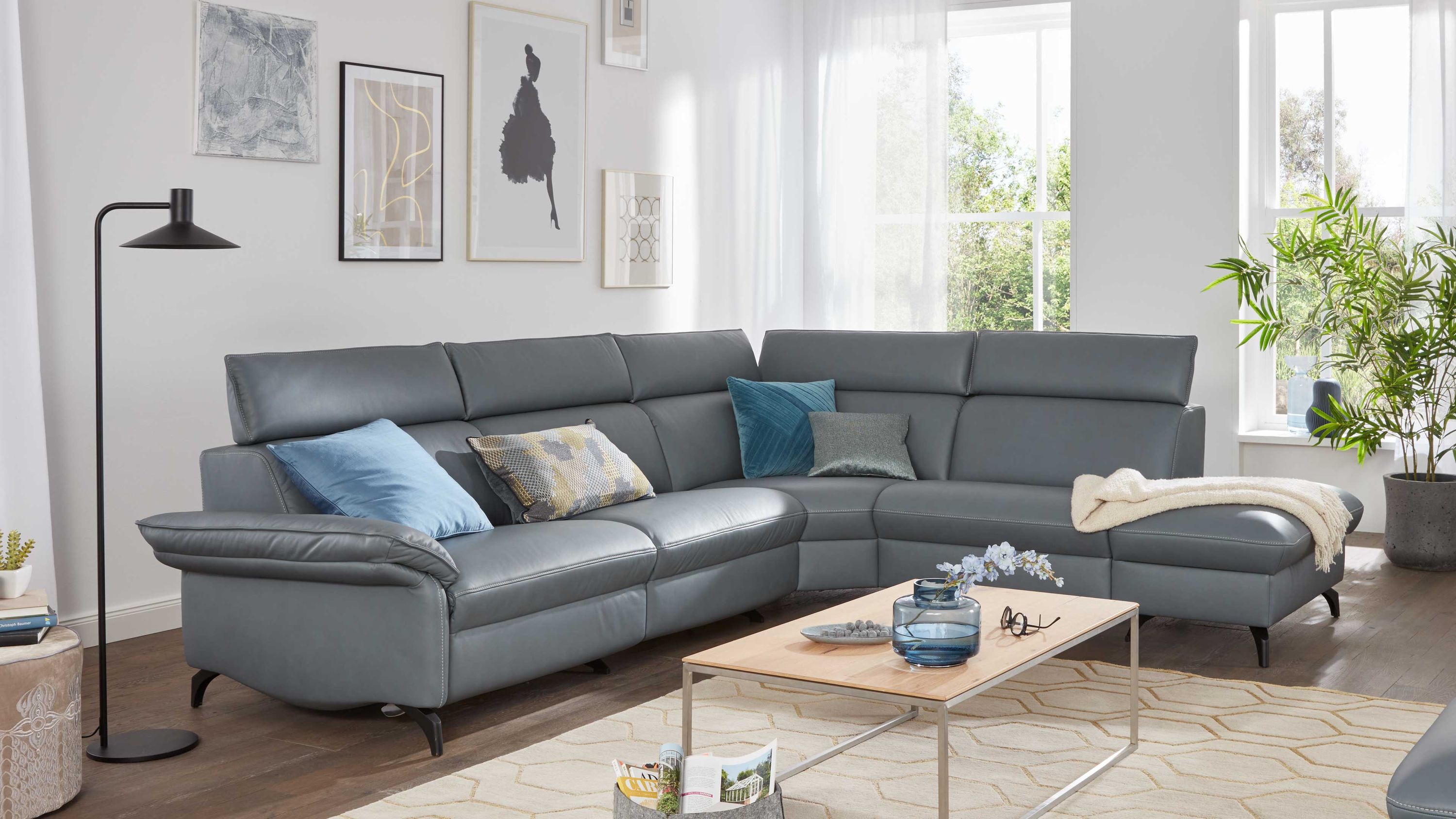 Ecksofa mit verstellbaren Kopfstützen in seefarbenem Leder mit schwarzen Füßen und mehreren Kissen