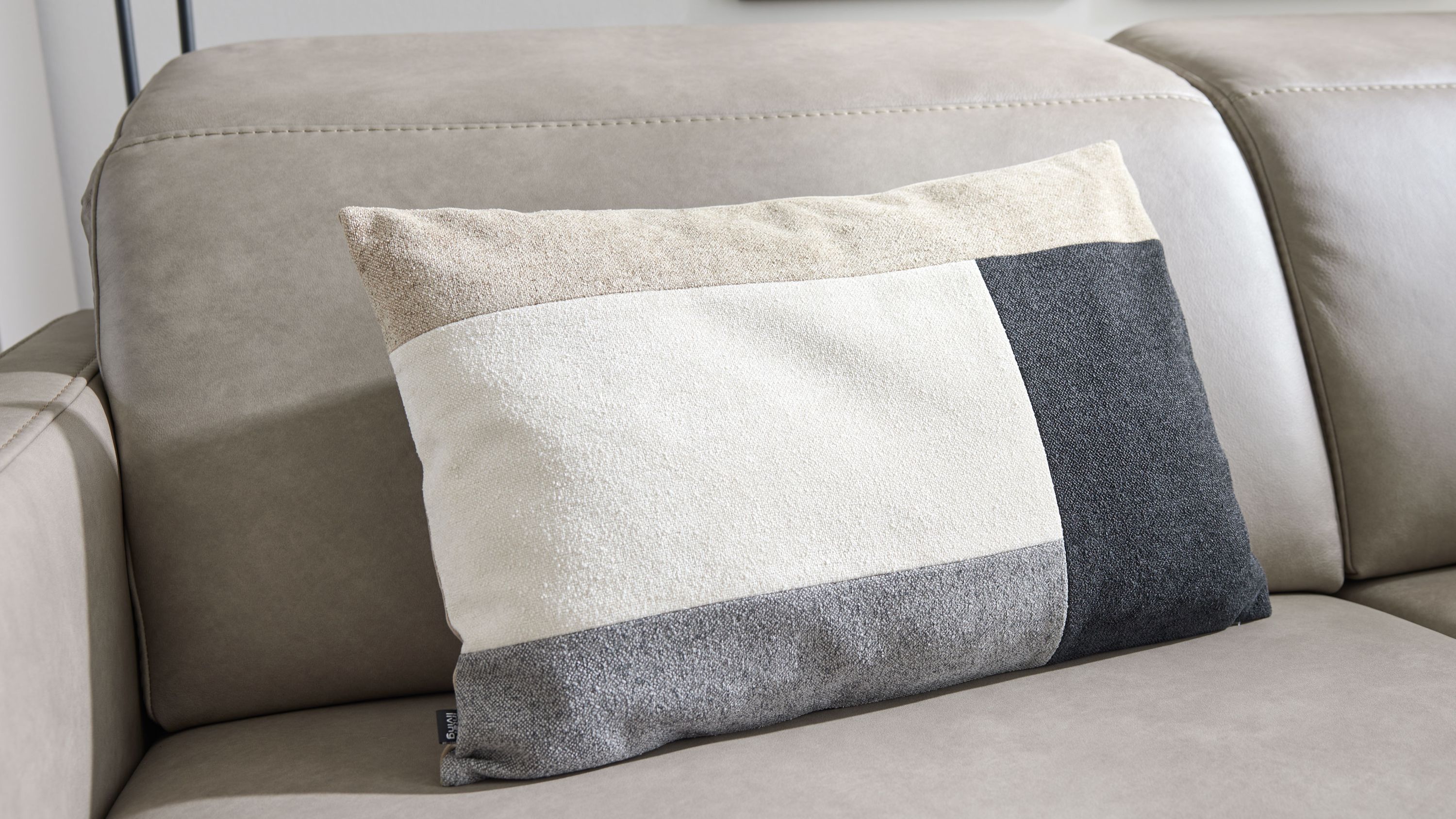 Rechteckiges Kissen mit Blockstreifen in Sand- und Blautönen Rechteckiges Kissen mit Blockstreifen in Sand Weiß Grau und Dunkelblau auf einem hellen Sofa