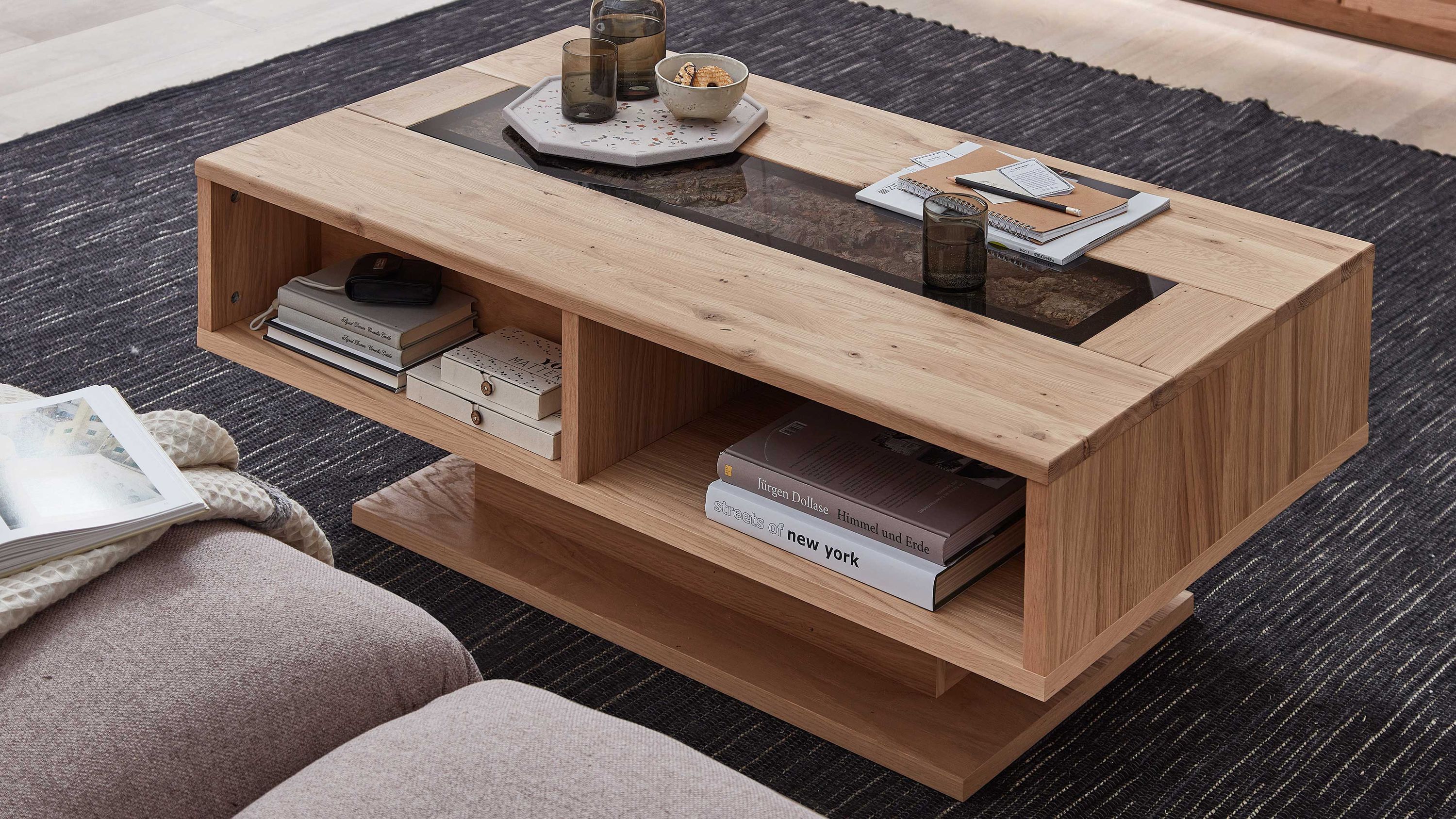Couchtisch mit offenem Fach und Glasplatte in heller Holzoptik Rechteckiger Couchtisch mit offenem Fach und Glasplatte in heller Holzoptik auf dunklem Teppich