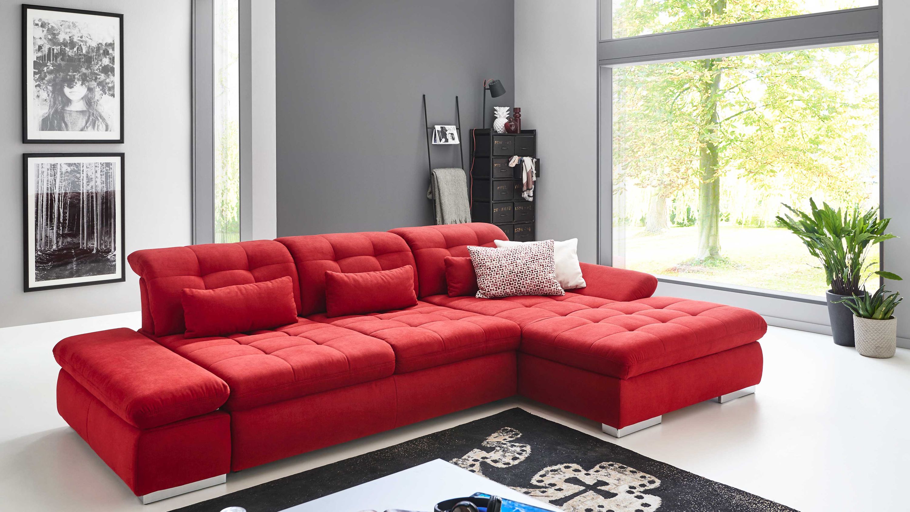 Rotes Ecksofa mit gepolsterten Rückenlehnen und chromfarbenen Rollenfüßen in modernem Wohnzimmer