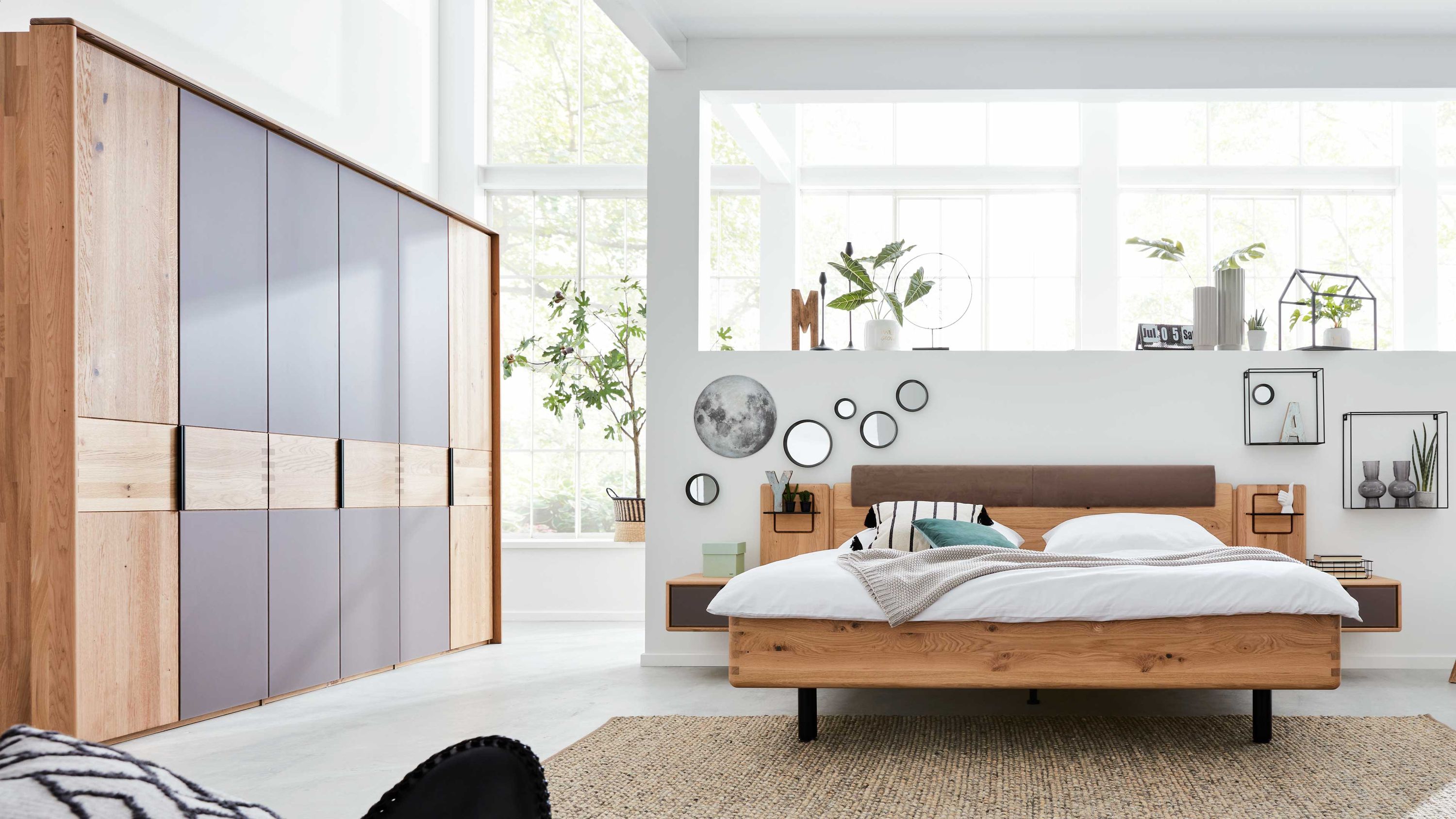 Schlafzimmer mit Bett und Kleiderschrank in Holz und Grau Schlafzimmer mit Holzbett und großem sechstürigem Kleiderschrank in Holz und grauen Fronten