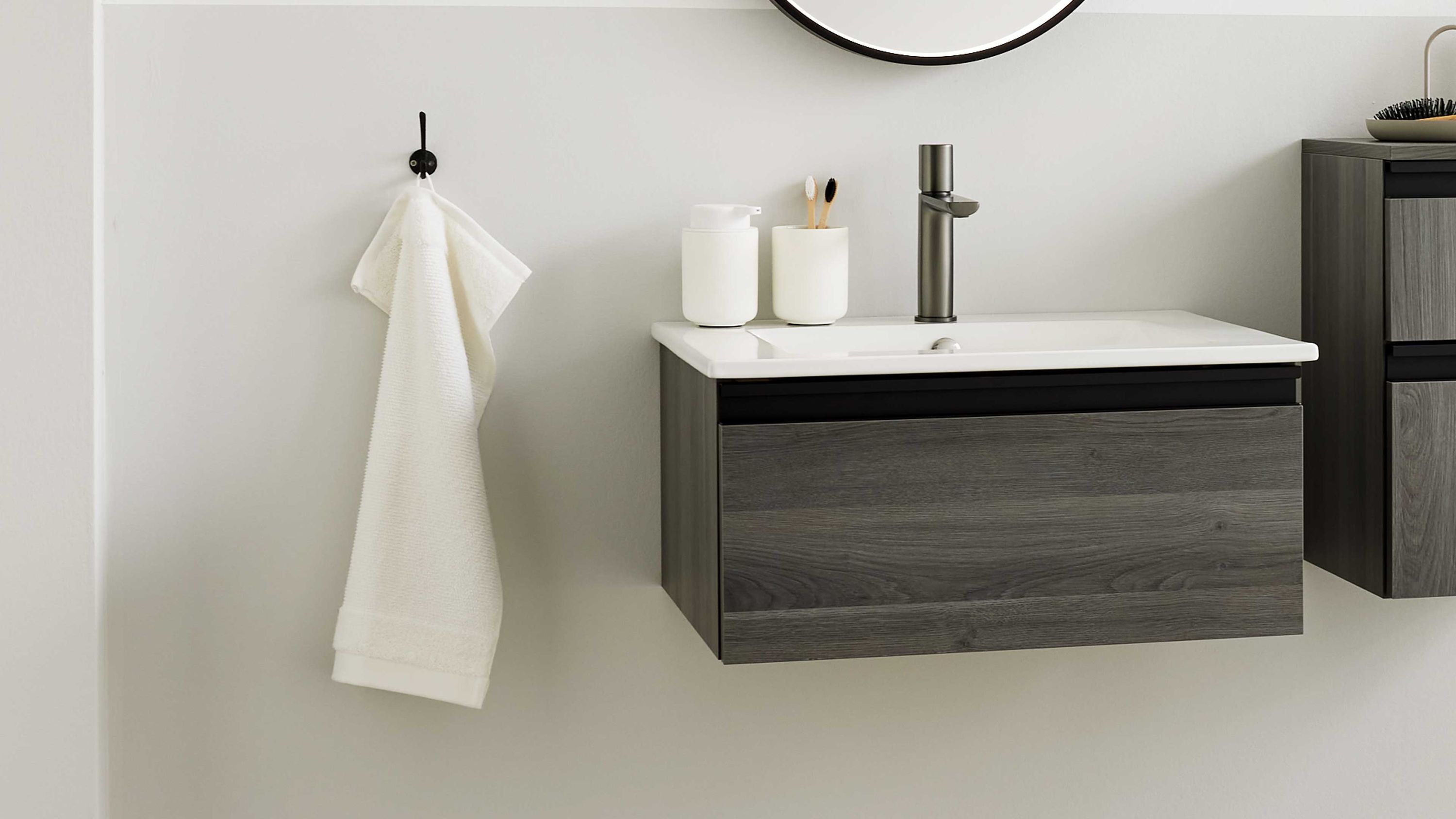 Hängender Waschtisch mit grauer Holzfront und weißem Becken Hängender Waschtisch mit grauer Holzfront und weißem Waschbecken in modernem Bad