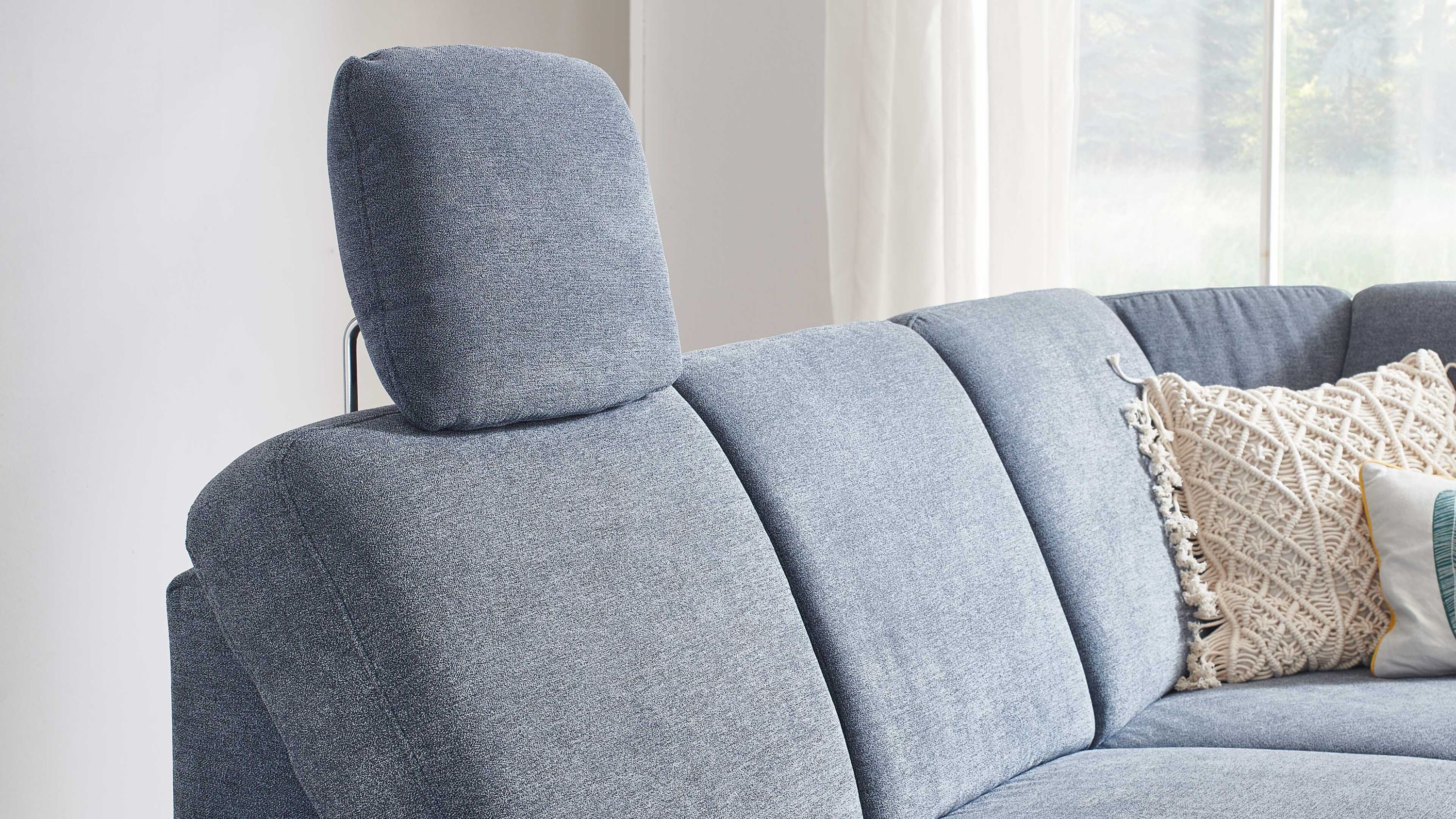 Denimfarbene Kopfstütze auf einem blauen Sofa mit mehreren Kissen