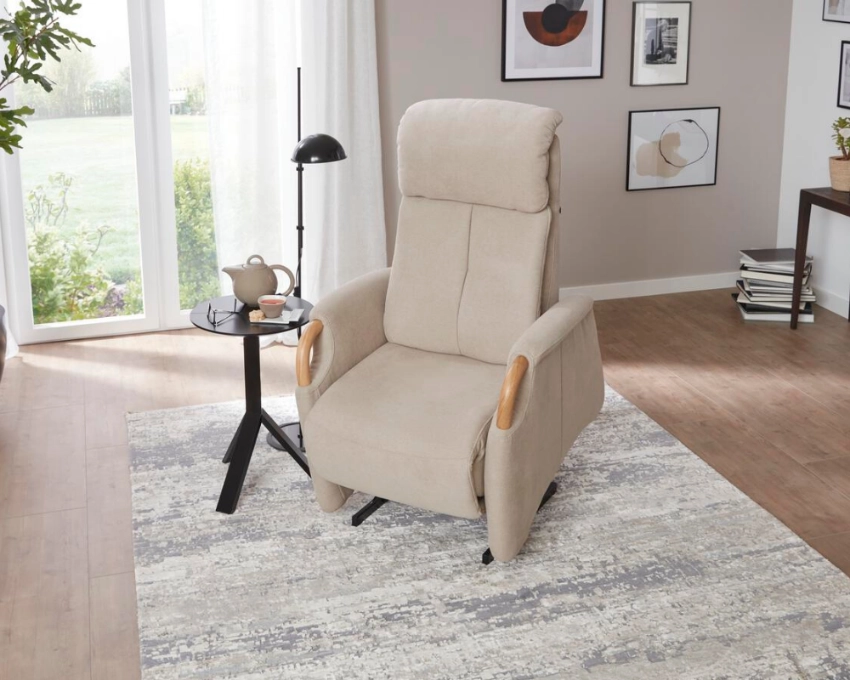 Ergonomischer Relaxsessel im modernen Wohnzimmer mit Tageslicht Beiger Relaxsessel auf hellem Teppich vor Fenster, daneben Beistelltisch, wohnliches Wohnzimmerambiente