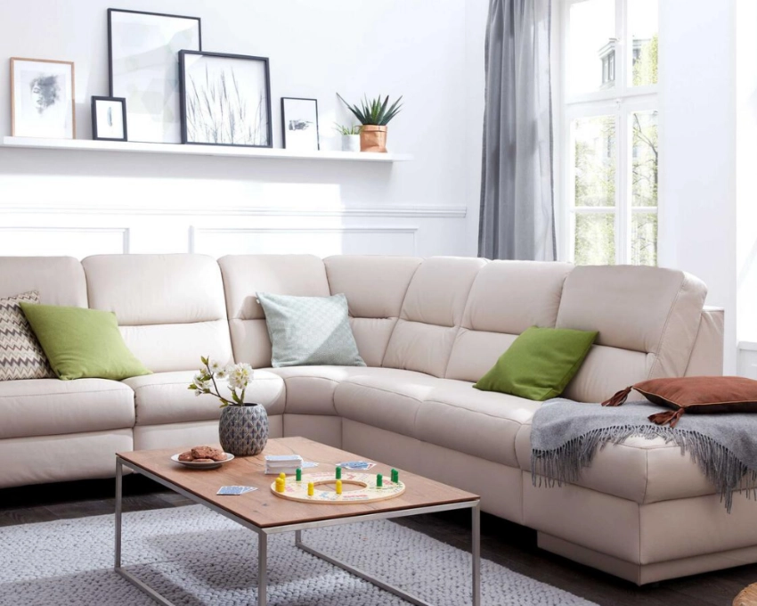 Hellgraue Wohnlandschaft von Himolla Großzügiges Sofa in hellgrau mit grünen Kissen, modern eingerichtetem Wohnzimmer