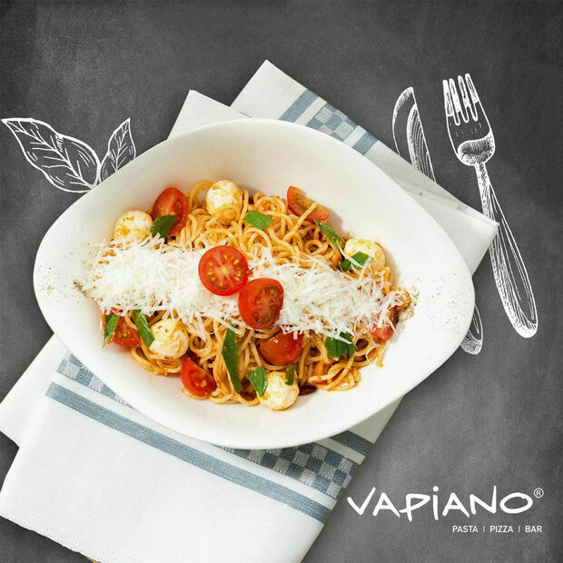 Ovaler Porzellanteller Villeroy & Boch Vapiano angerichtet mit Pasta Tomaten Kräutern auf gestreifter Serviette