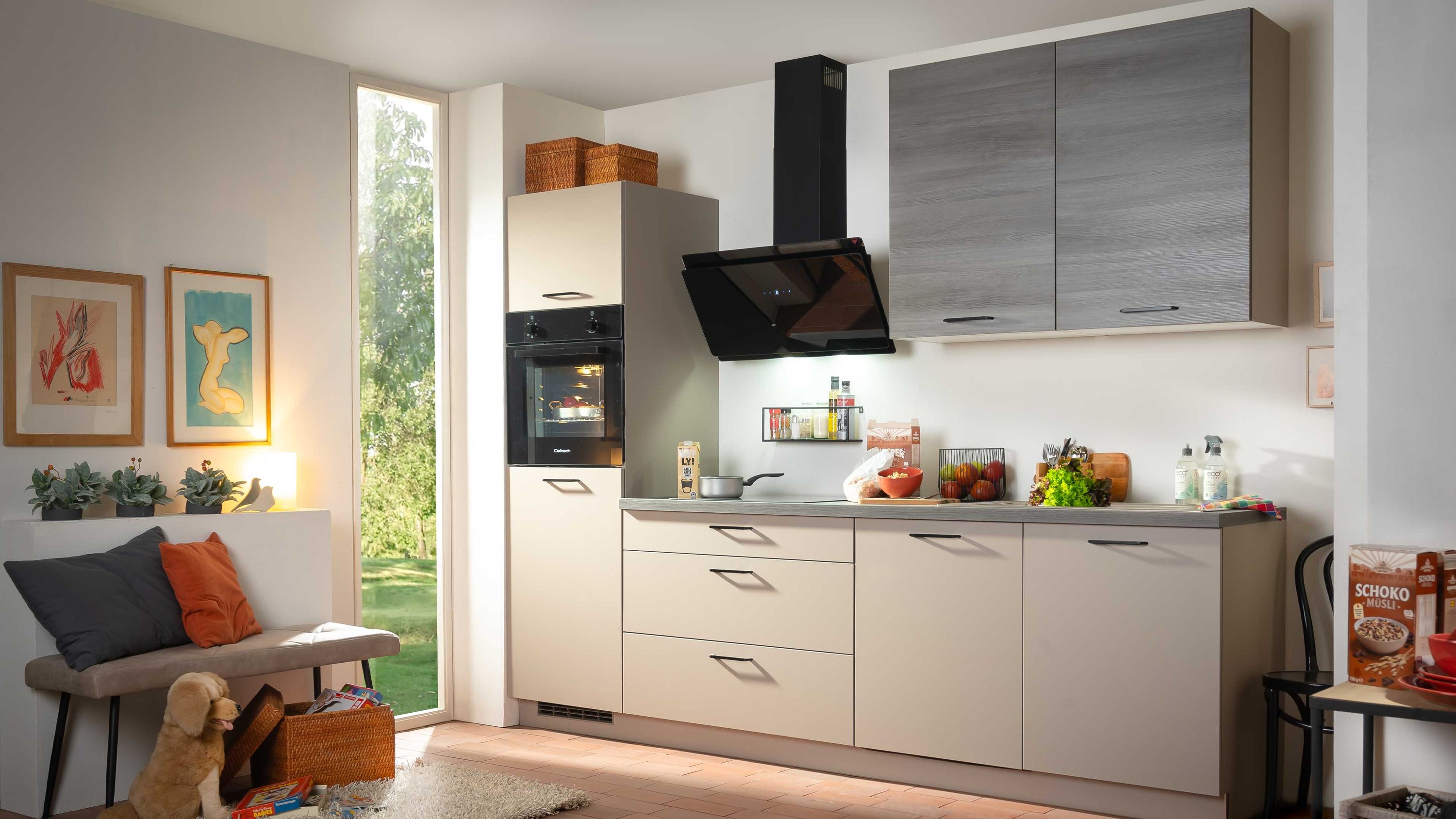 Zeitlose Küche in Beige und Grau. Kompakte Küche in Beige mit grauen Hängeschränken und moderner schwarzer Dunstabzugshaube.