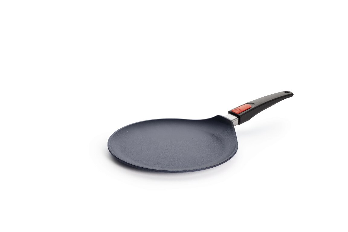 Flache WOLL-Crépepfanne mit Antihaftbeschichtung und ergonomischem Griff mit rotem Knopf.