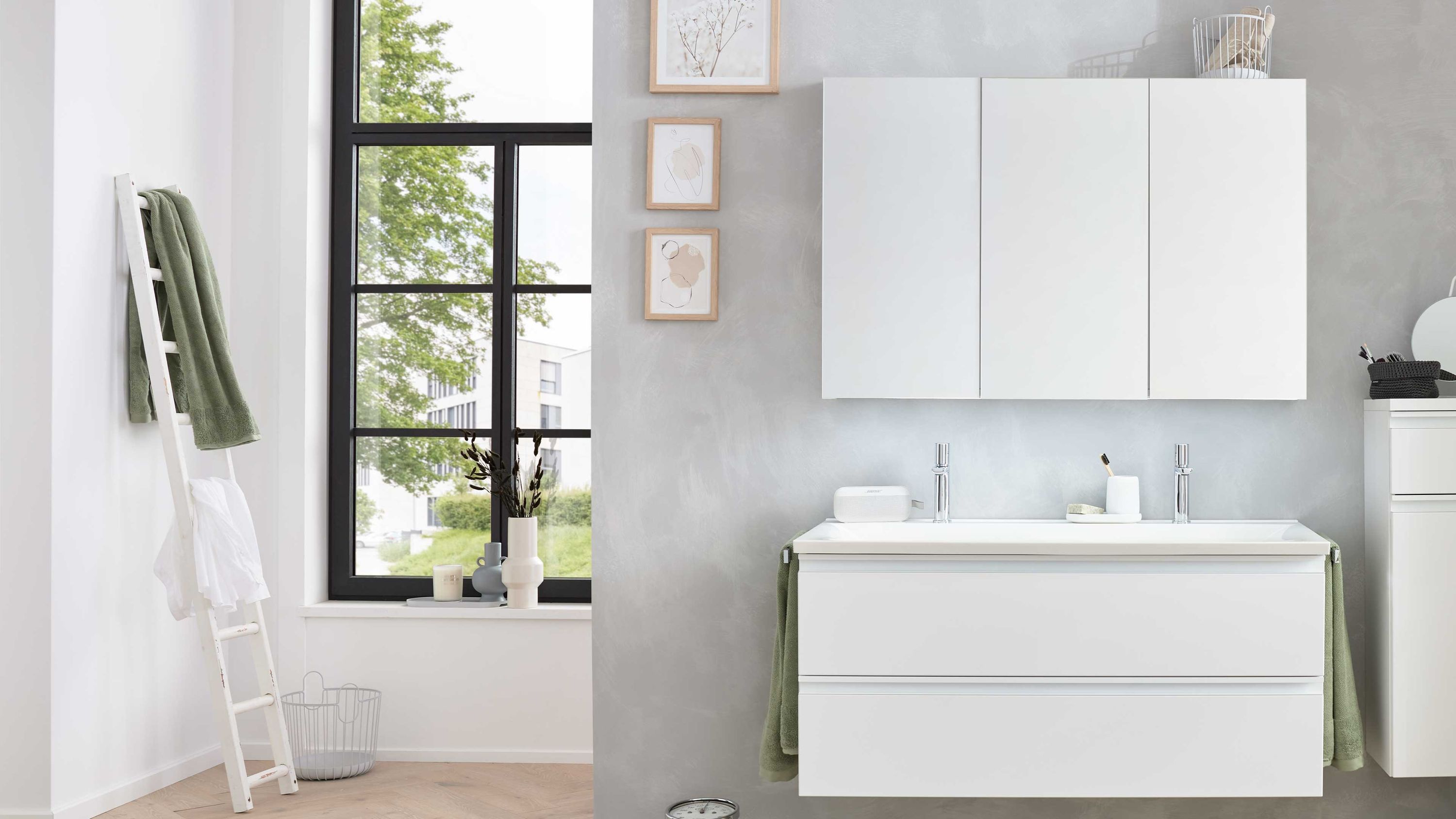 Dreiteiliges weißes Badmöbel-Set mit Spiegelschrank und Unterschrank Dreiteiliges weißes Badmöbel-Set mit Wandspiegelschrank Waschbeckenunterschrank und Hochschrank vor grauer Wand