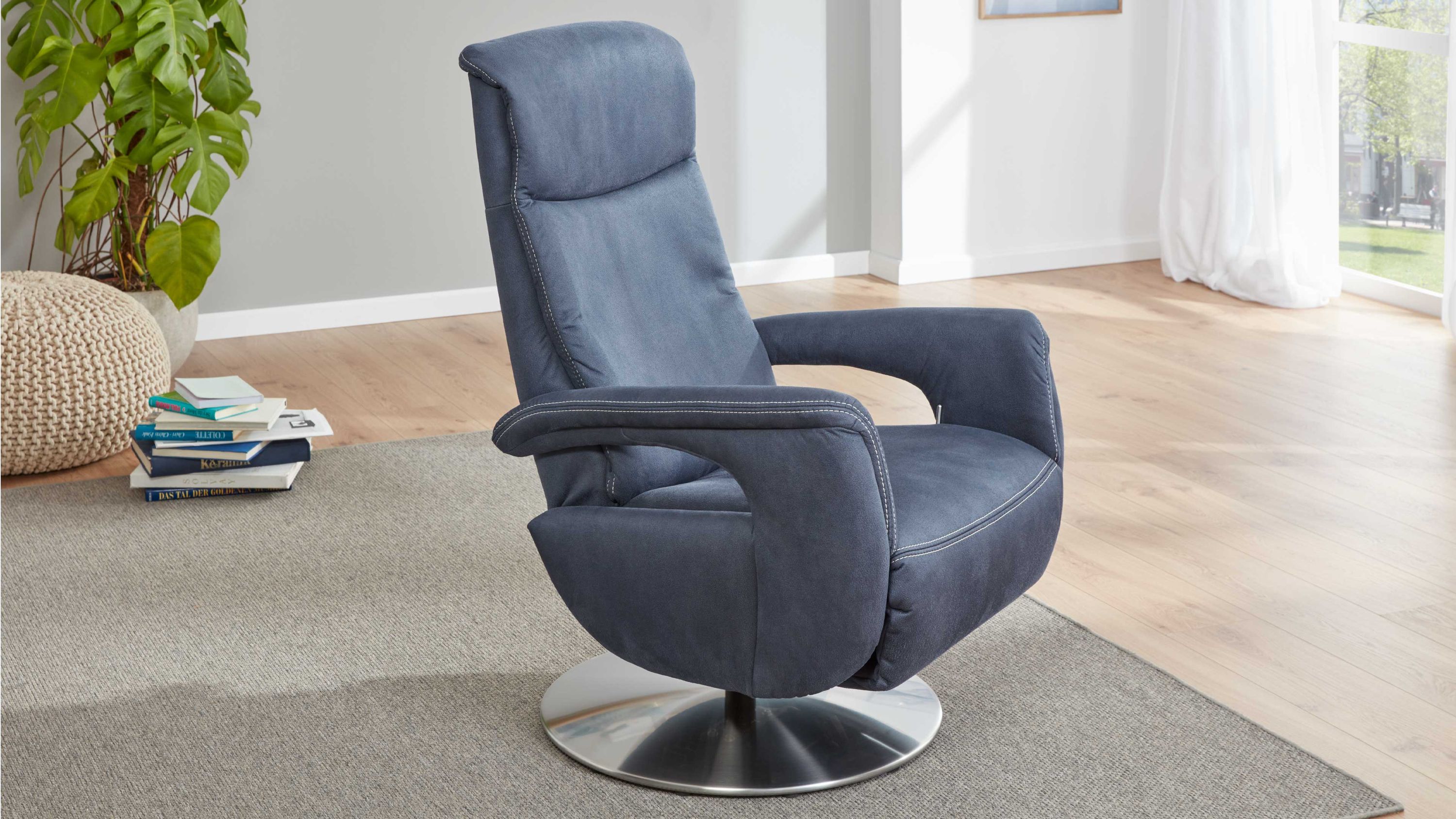 Blauer Relaxsessel mit Chrom-Tellerfuß Blauer Relaxsessel mit hoher Rückenlehne und Chrom-Tellerfuß in hellem Raum