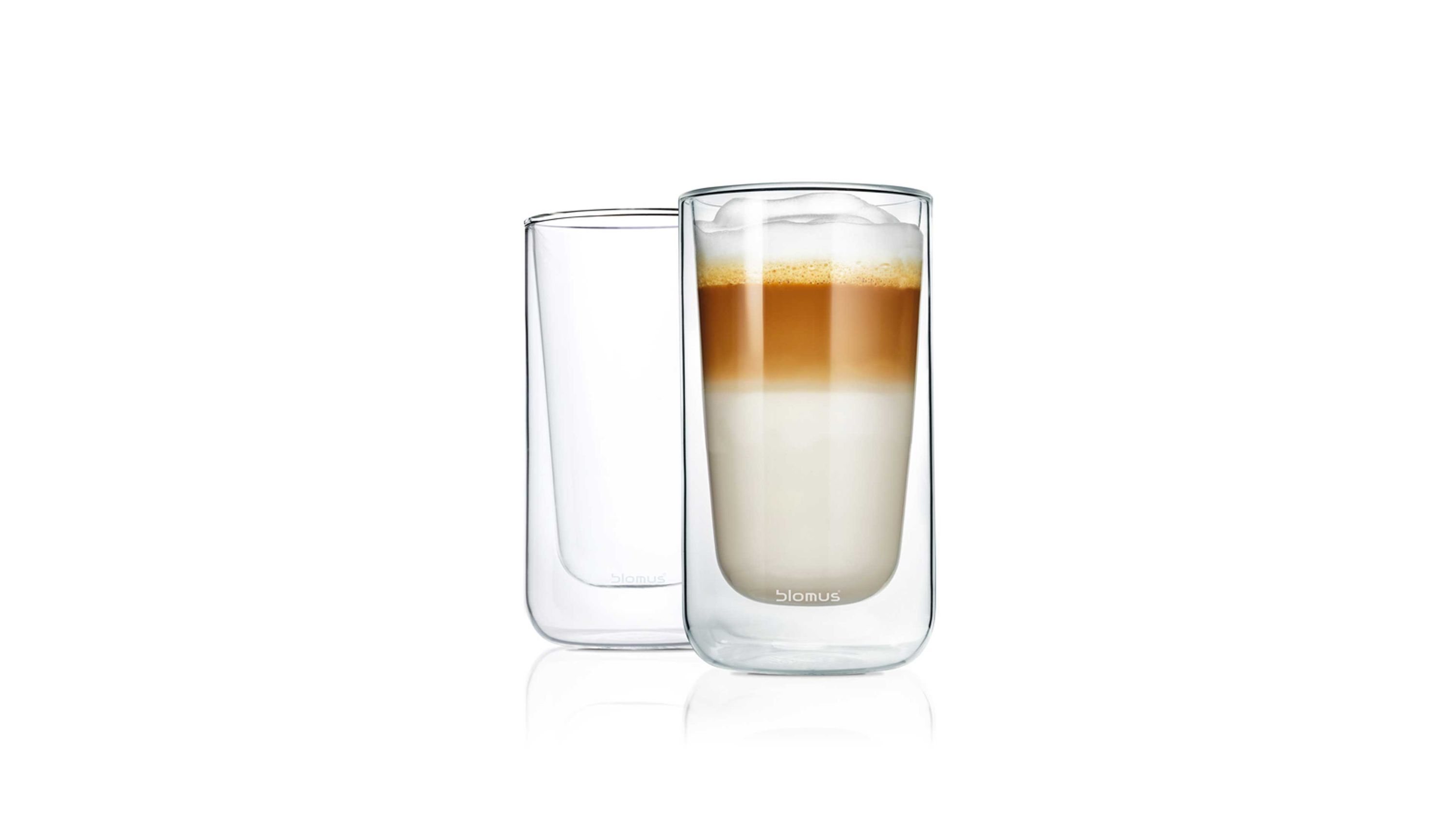 Zwei transparente Doppelwandgläser eines gefüllt mit geschichtetem Kaffeegetränk