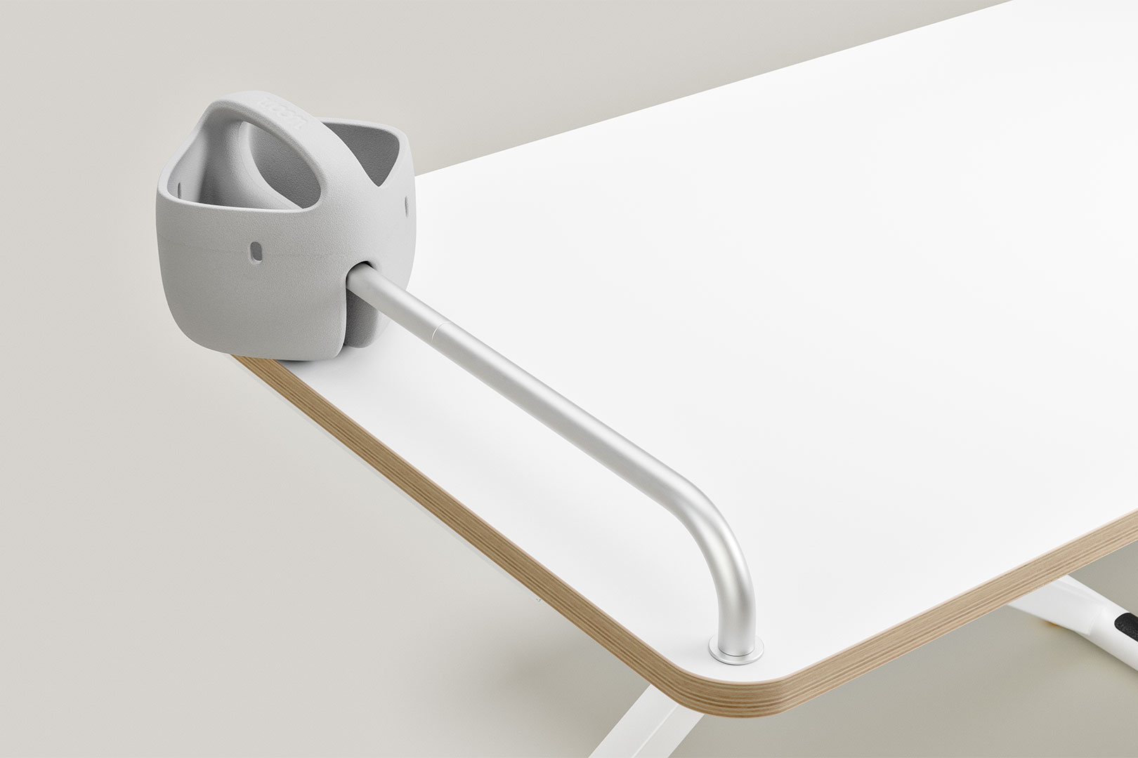 Grauer Stiftehalter mit Metallstange am weißen Schreibtisch befestigt