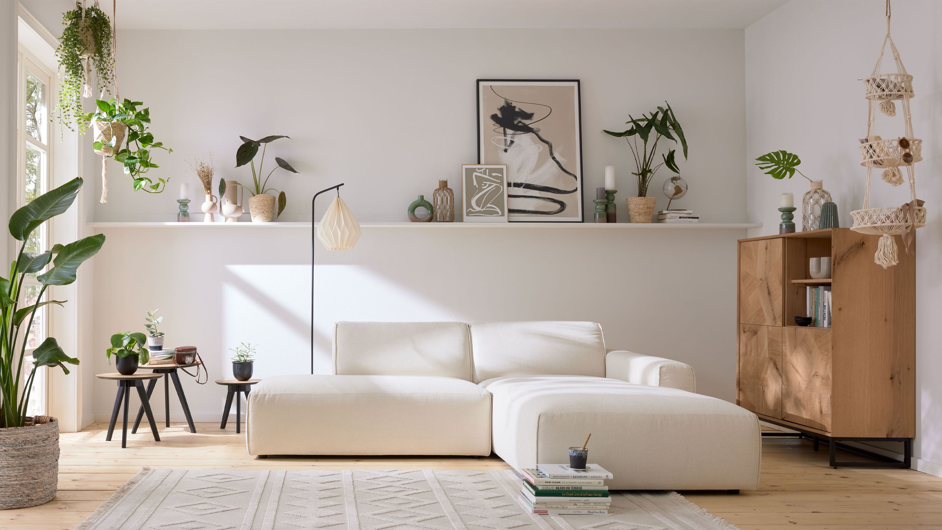 Schneeweißes Ecksofa mit Chenillebezug Ecksofa in schneeweiß mit zwei Sitzflächen und Rückenlehnen in einem hellen Wohnzimmer