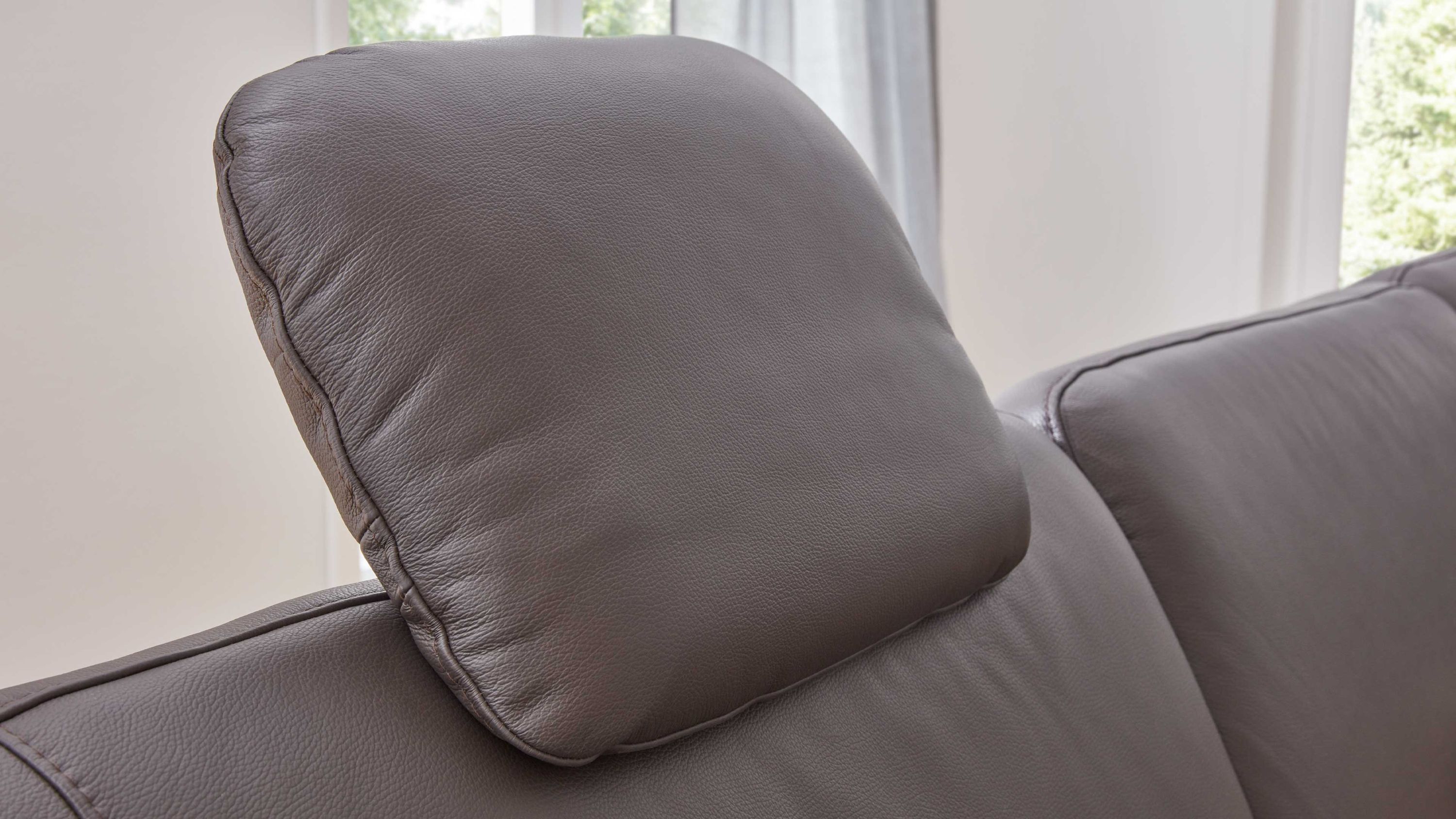 Kopfstütze in schokoladenbrauner Farbe auf einem Sofa mit glatter Oberfläche