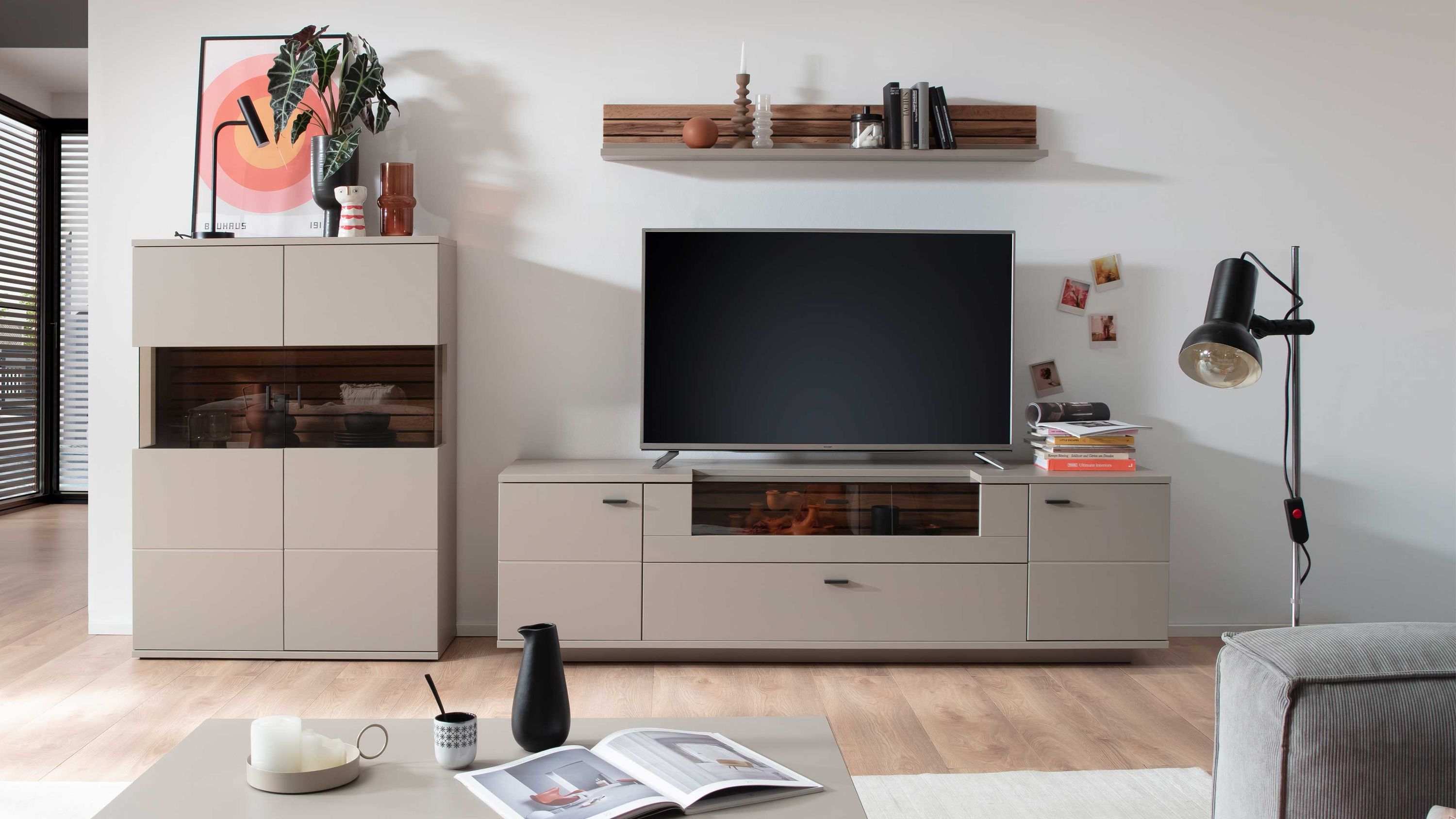 Dreiteilige Wohnwand in basaltgrau mit Holzoptik Dreiteilige Wohnwand mit Schrank TV-Board und Wandregal in basaltgrau mit Holzoptik dekoriert mit Büchern und Pflanzen