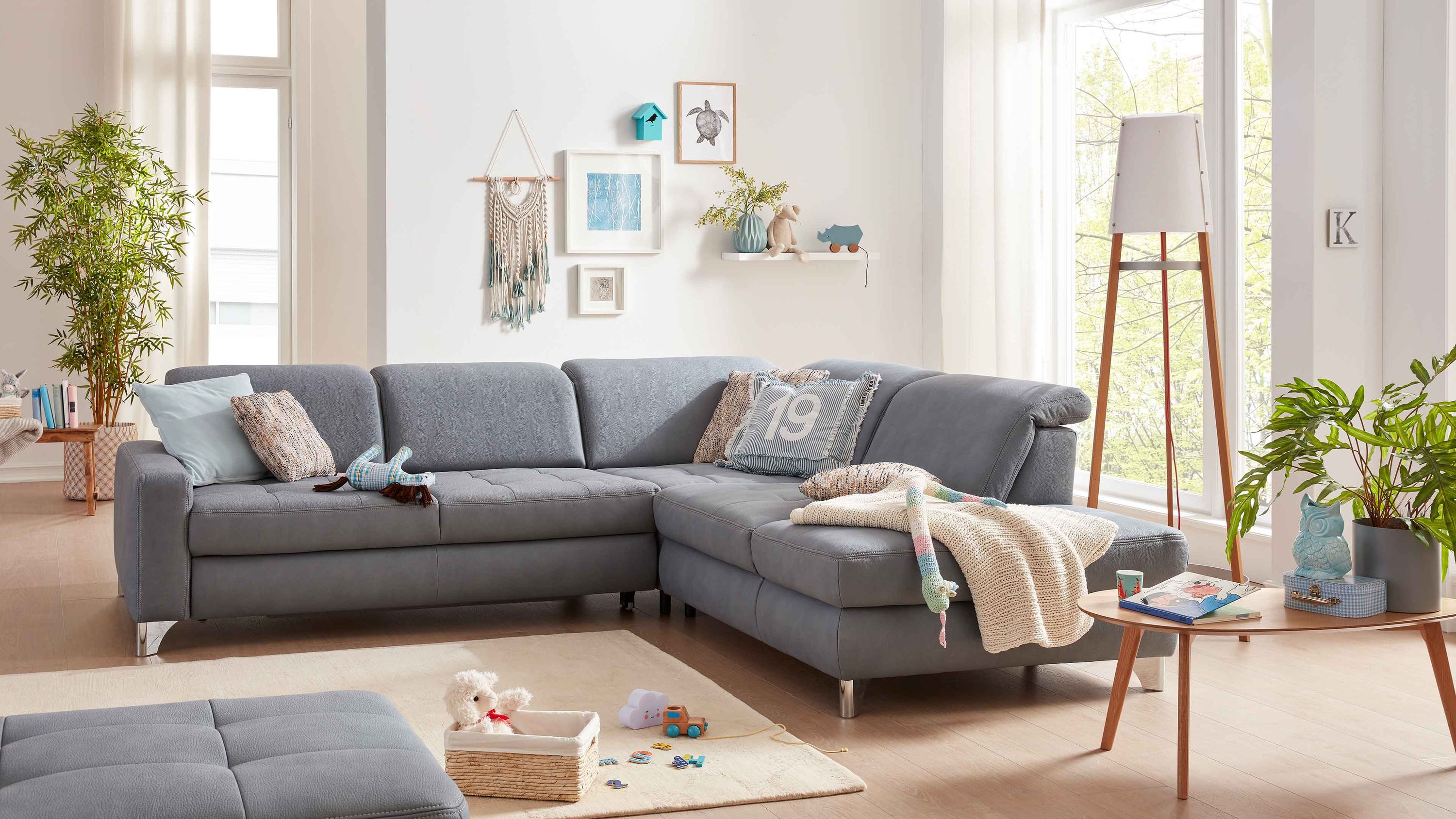 Ecksofa mit stahlfarbenem Mikrofaserbezug und glänzenden Winkelfüßen in hellem Wohnzimmer