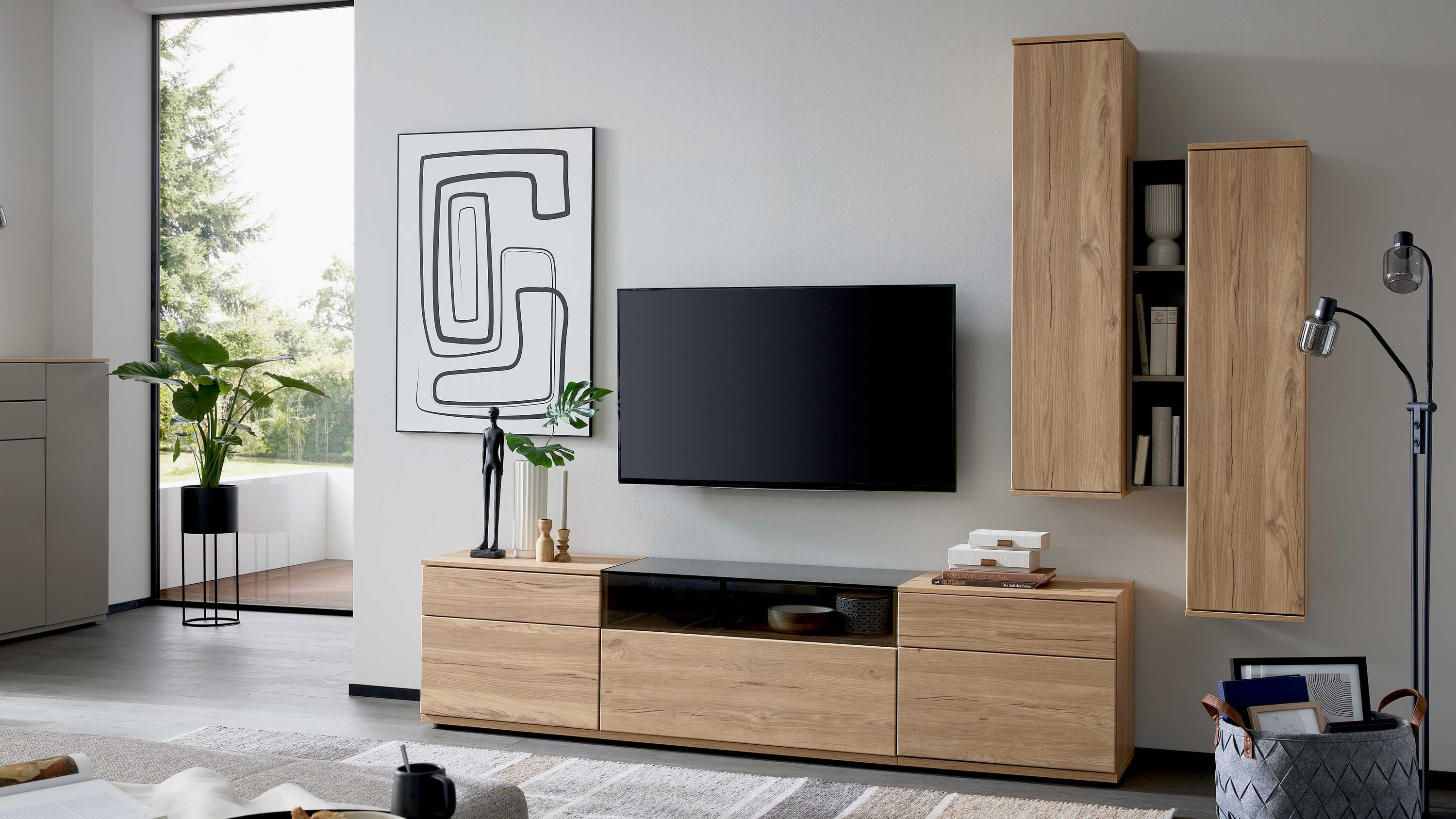 Wohnwand mit Hängeschränken und Lowboard in Holzoptik Wohnwand aus Holzoptik mit zwei hohen Hängeschränken und einem Lowboard mit schwarzen Elementen