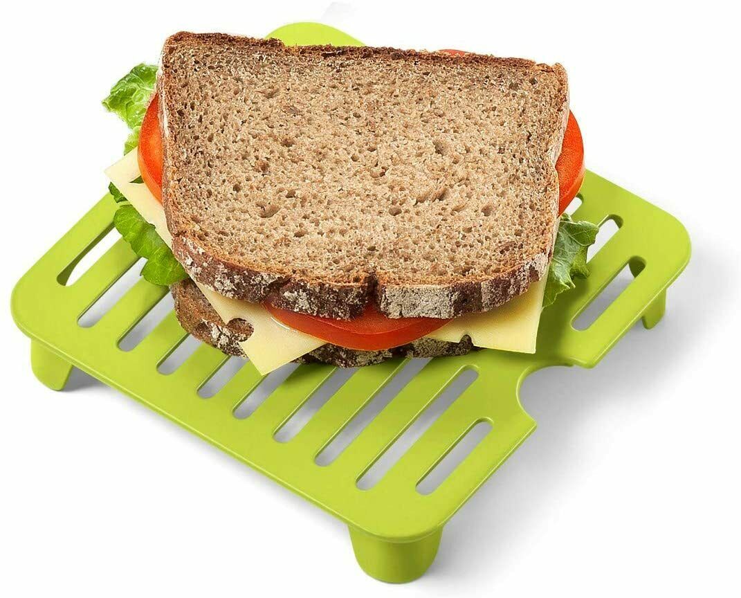 Brunchbox transparent-grün mit Deckel  darauf ein belegtes Sandwich mit Salat  Tomate und Käse